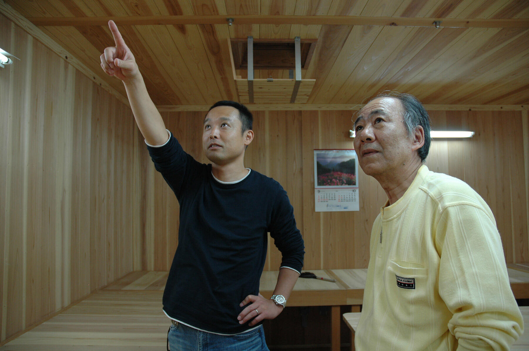 柔和な表情で改装した麹室に山中さんを案内する石原さん