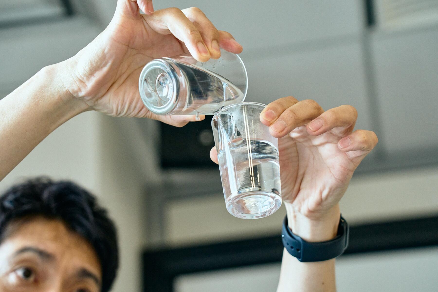 湯を入れたグラスに焼酎を注ぐ