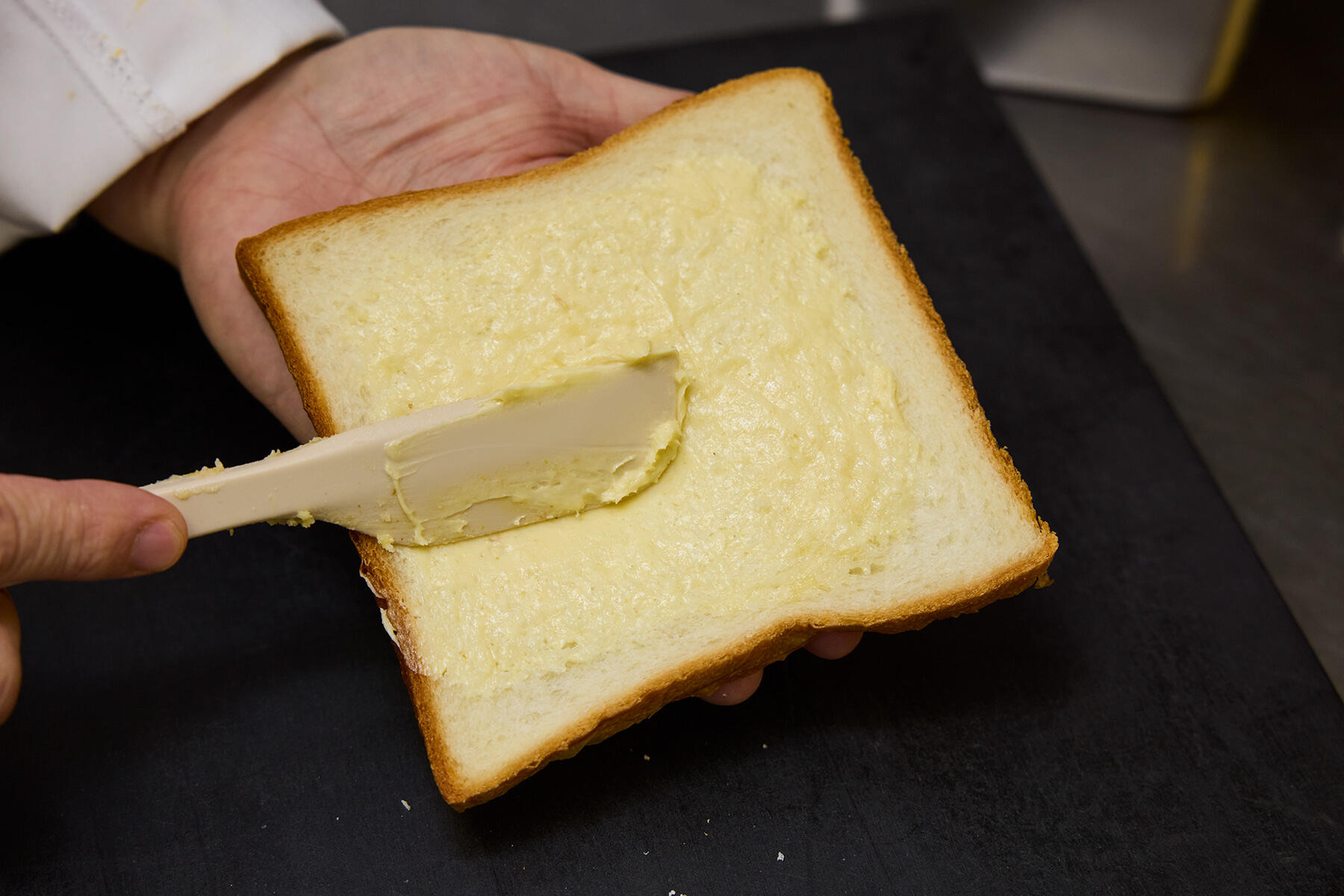 パンにマスタードバターを塗る
