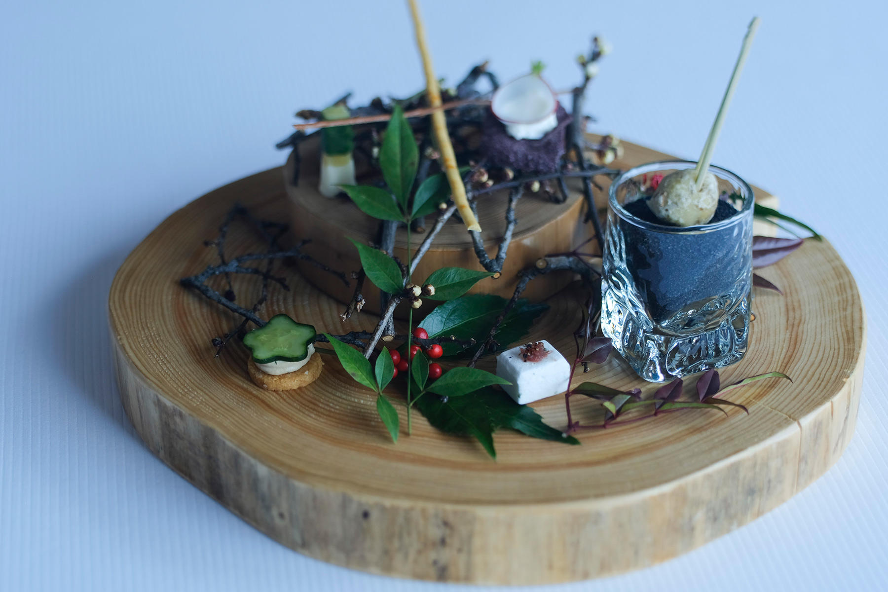 日本の「ピエール・ガニェール」では、どのコースにもウェルカムフードとして最初に登場するひと皿。手前から順に右へ“じゃがいもとフォアグラ、クミンのコロッケ”。“エストラゴンのギモーブ エシャロットのレデュクション”。ちなみにレデュクションとは煮詰めることで、エシャロットをビネガーで煮詰めたものを添えている。“パルメザンのサブレ”。ツナとデイルの香るソースをのせ、きゅうりをトッピング。上の段には“黒米のチップスにソースサラソン ラディッシュのせ”とホワイトチョコレートでコーティングした“コンテチーズ”など。細いスティック状のものは、白が“ひよこ豆とエスブレッド唐辛子のスティック”で、黒が“シナモンのスティック”。料理の内容は季節によって変わっていく。