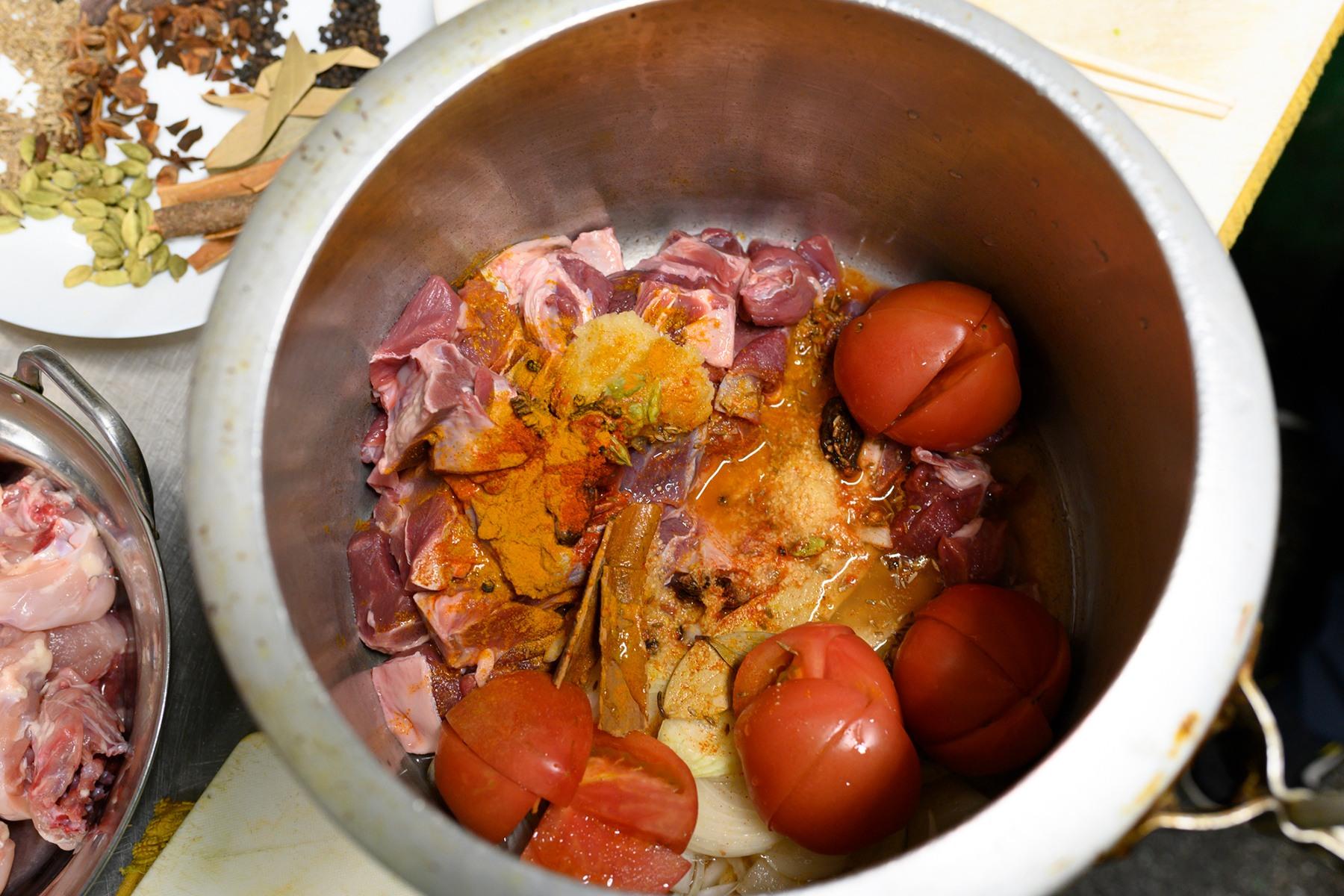 肉、野菜、スパイスを鍋に入れて、煮込む