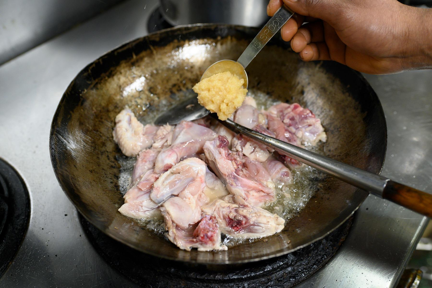 すりおろしたにんにくと生姜を加え、油で煮るように炒めていく。