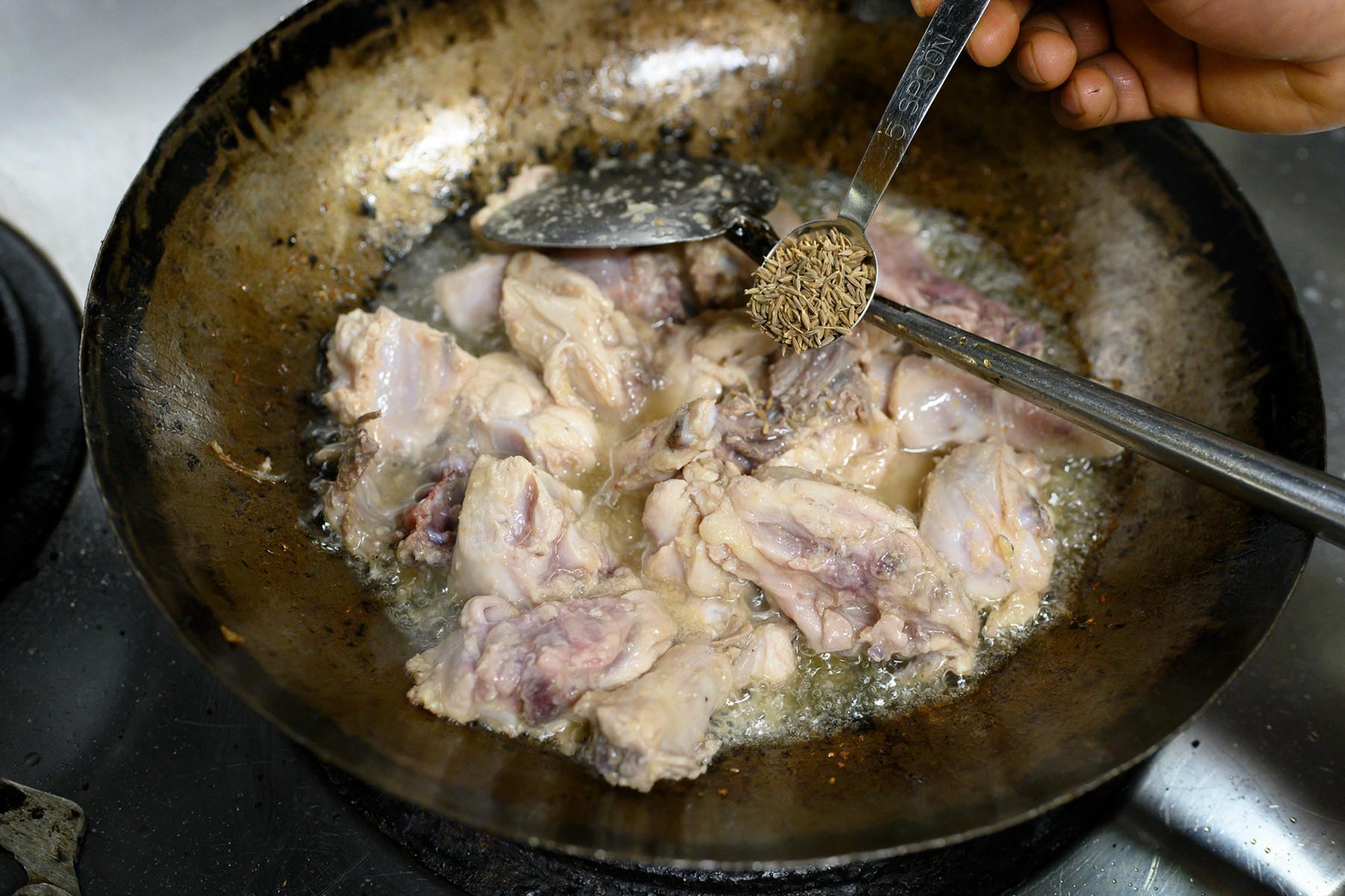 鍋を回したり揺らしたりしながら、ヘラで混ぜて炒める。油が多いため、鍋は返さないこと。