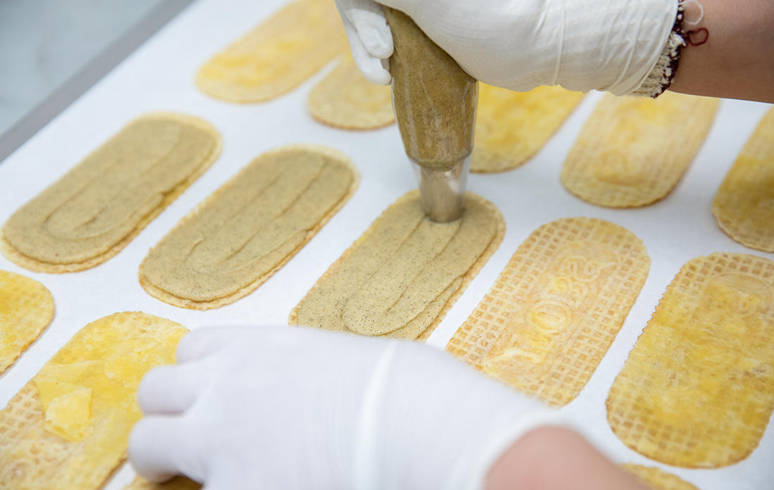 3種類の砂糖と2種類のバターでつくったクリームにたっぷりのバニラを加えたら、生地に絞っていく。均等の厚さに絞るのが難しいそうだ。