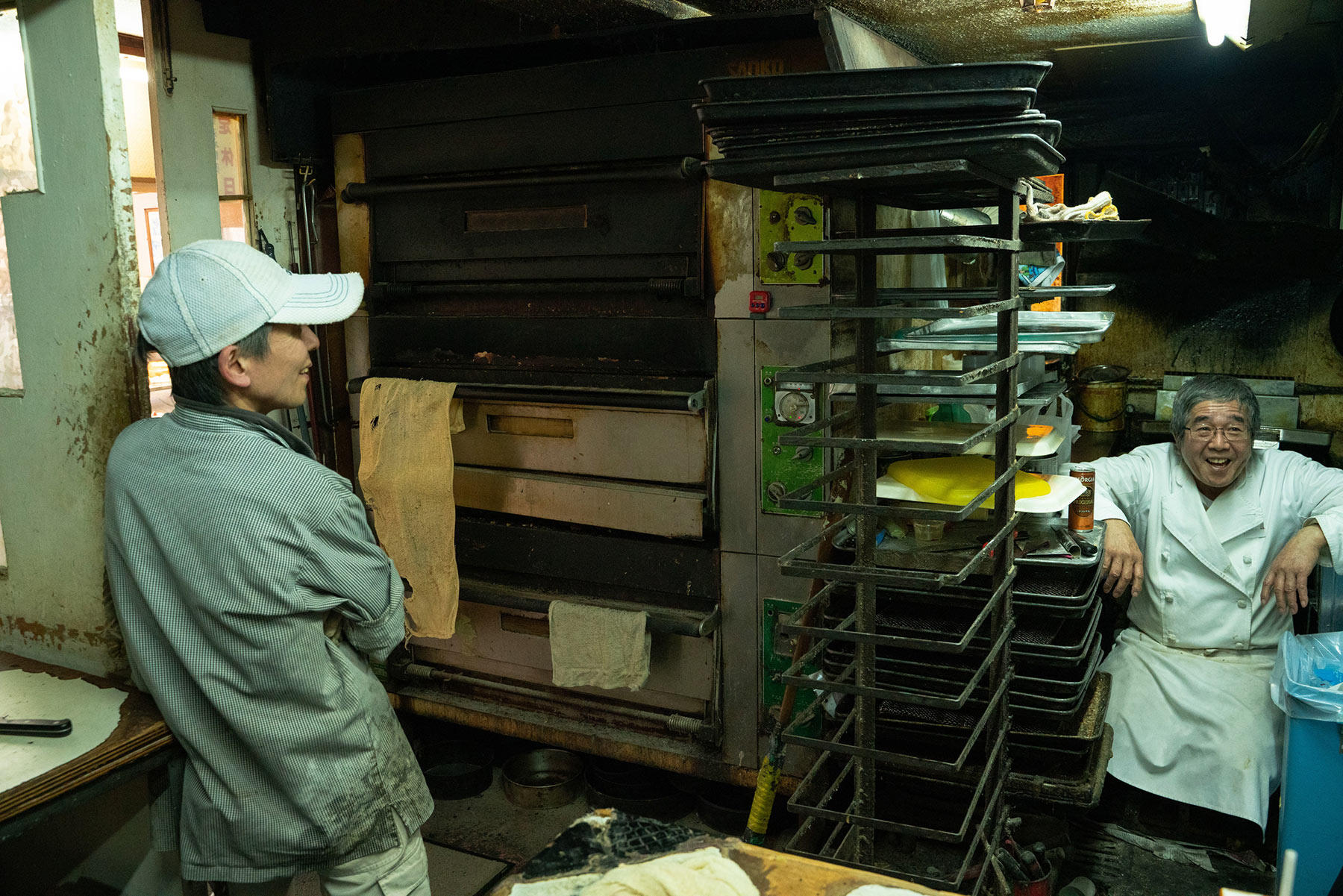 座っているのが、店主の藤村裕二さん。壁に寄りかかっているのは、パン職人の佐藤和男さん。