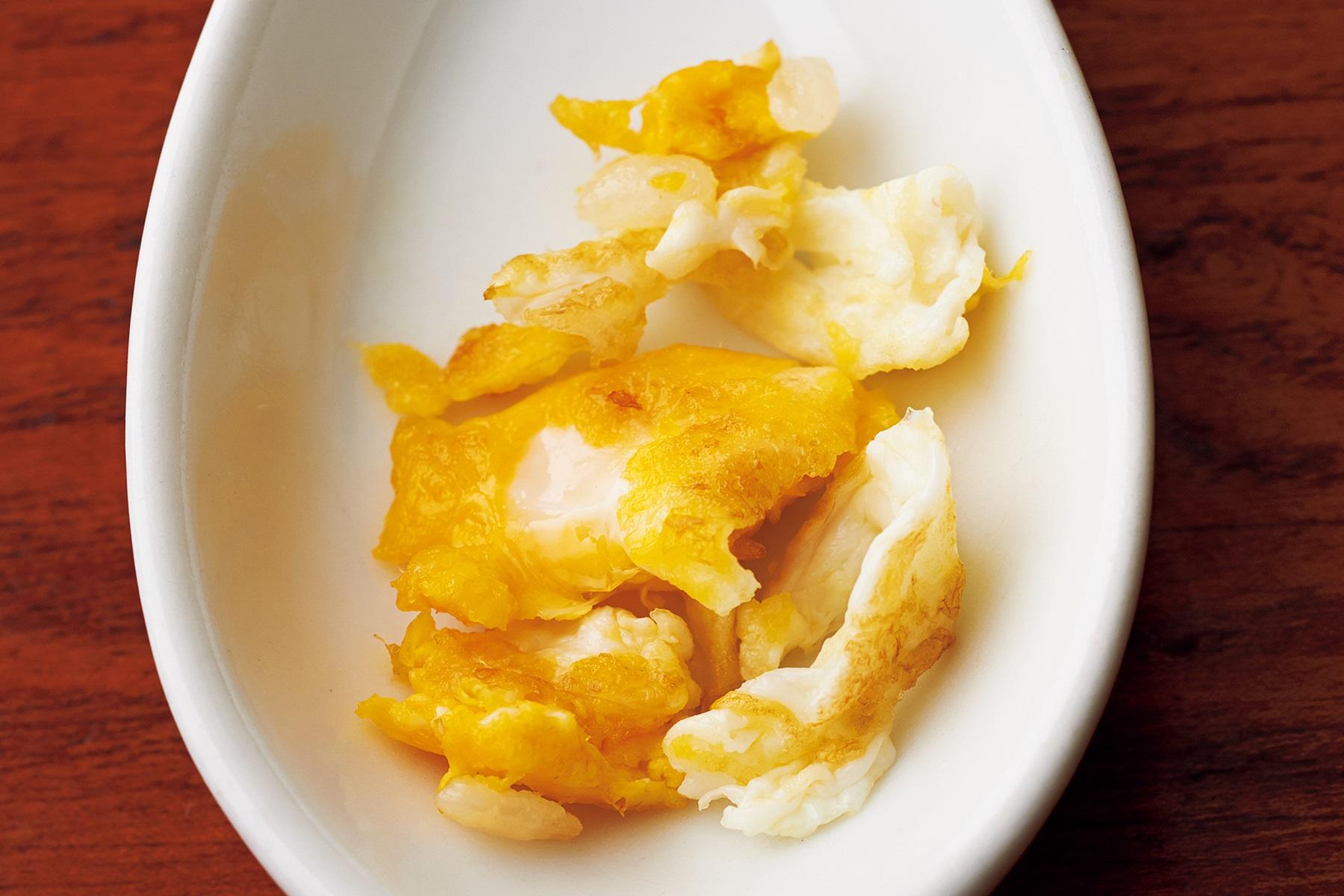 高温で炒めた卵は、油で揚げたような焼き色に仕上がる。油温が低いとふわふわにはなるが、卵の生臭さが残ってしまう。