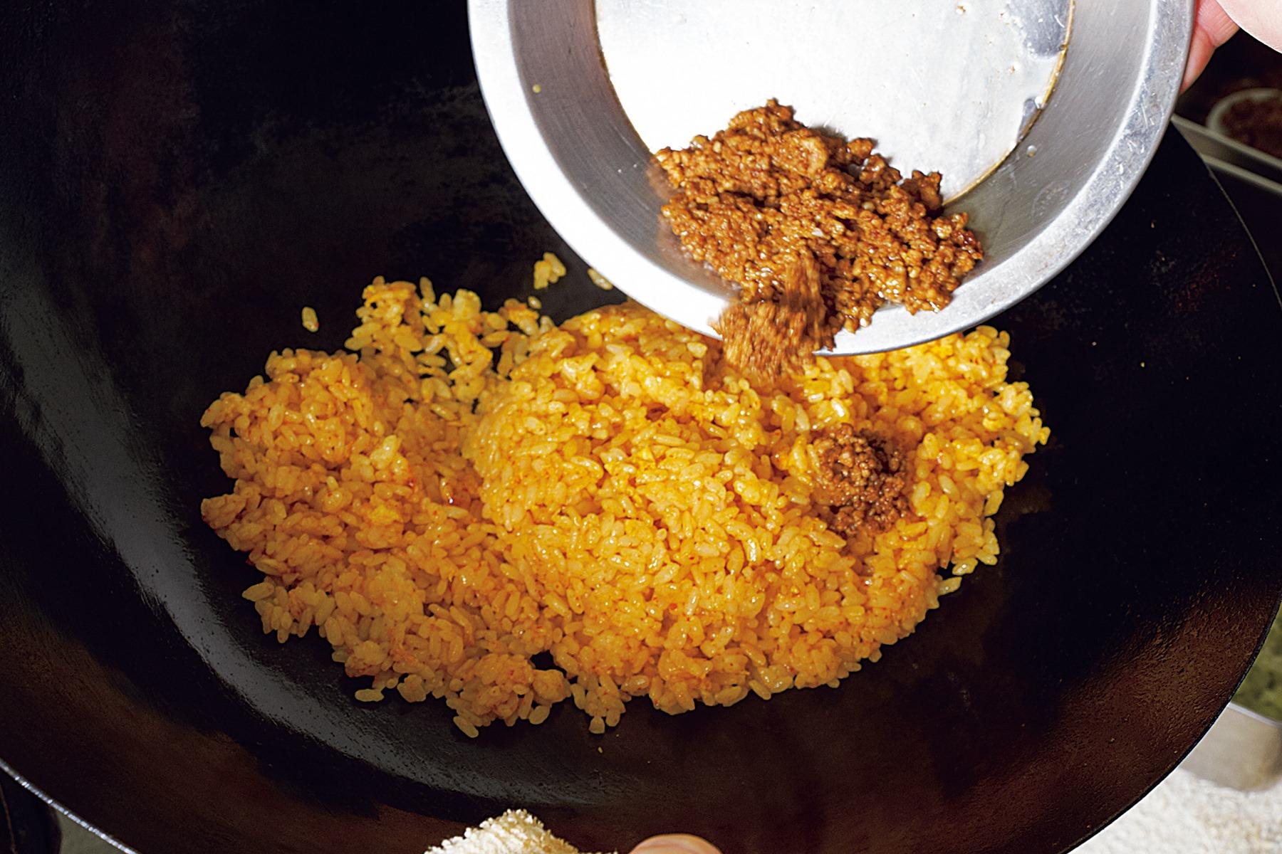 甜麺醤で甘く調味した挽き肉は最後に加えることで、辛味と香りをまとったごはんと完全に混ざりきることなく、味にメリハリが生まれる。