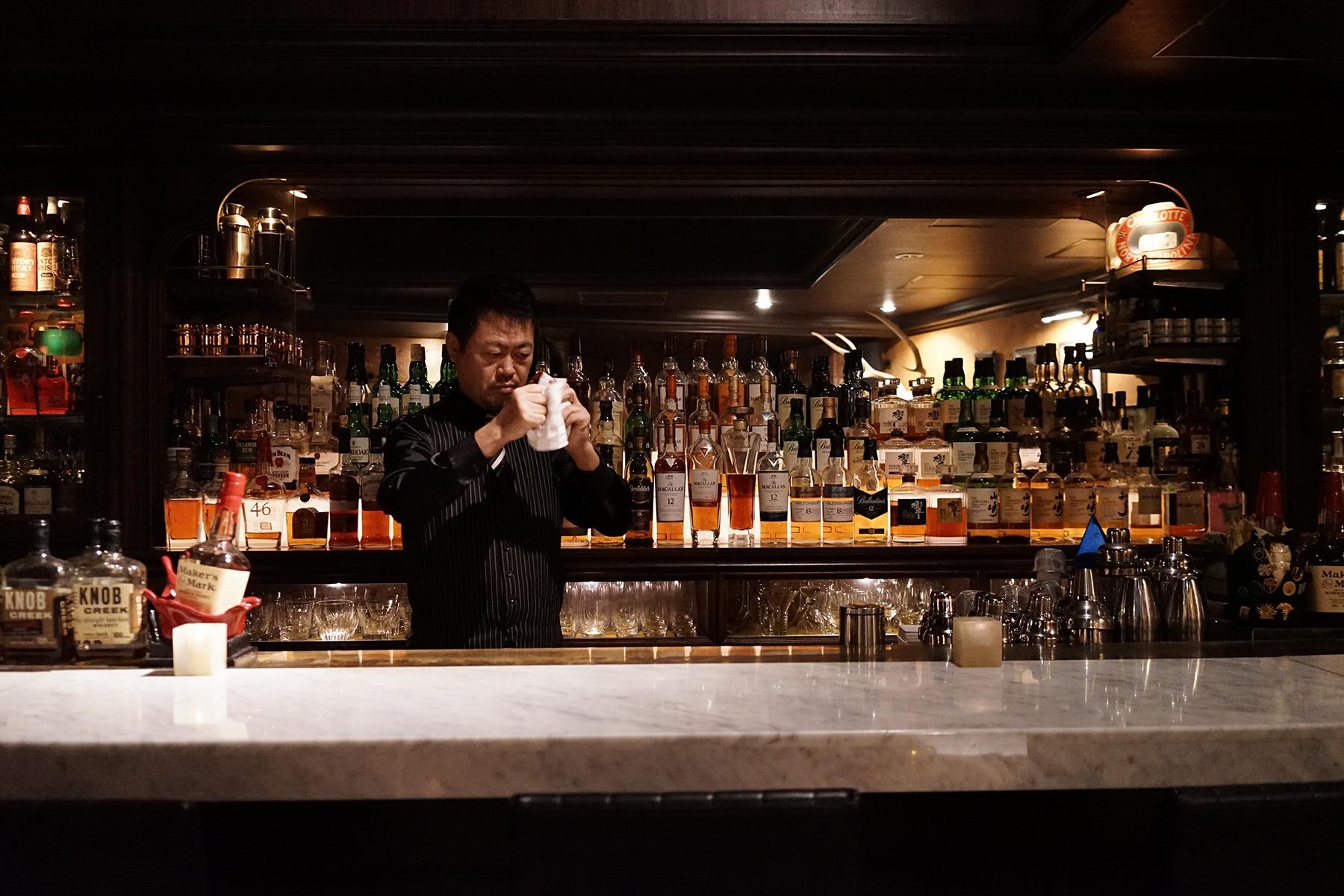 カウンター席がメイン。バックバーには洋酒のボトルが煌めく。