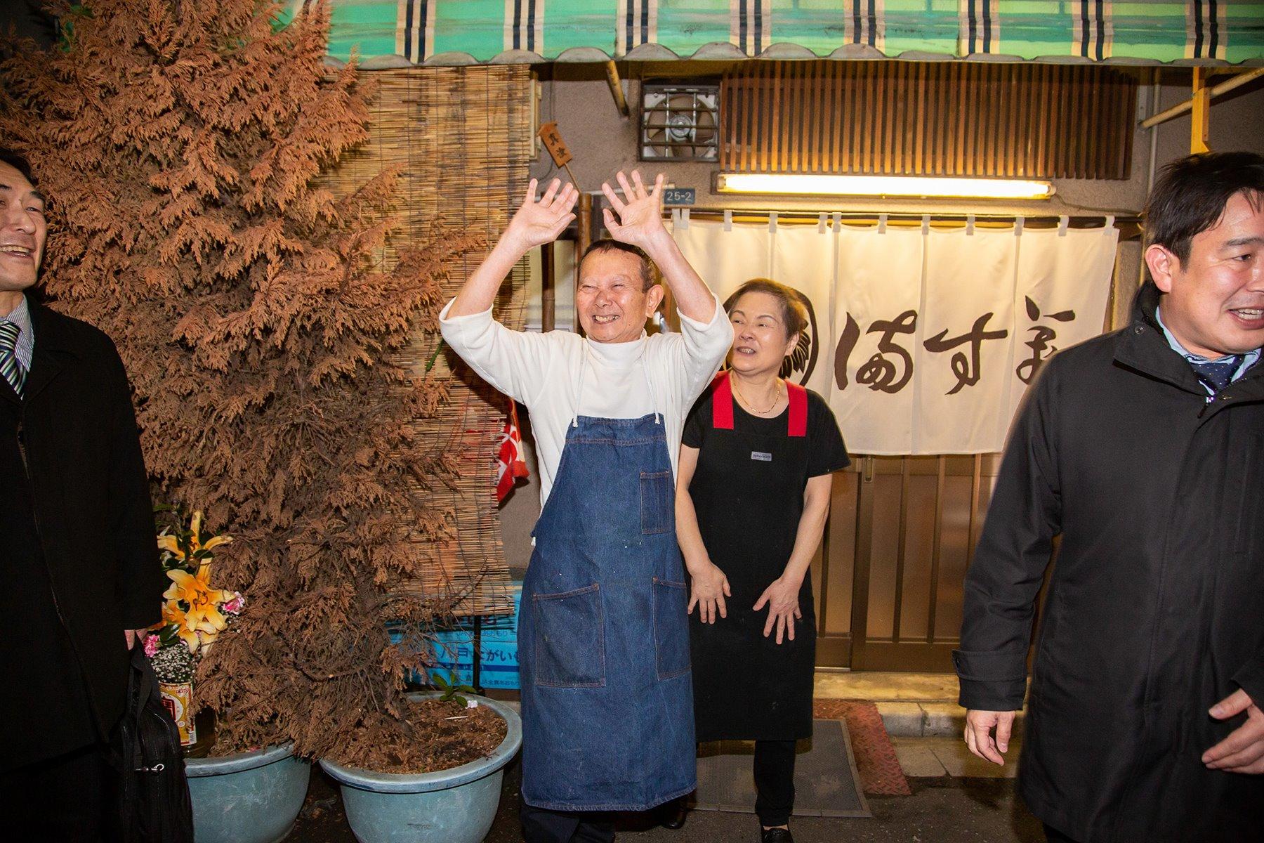 ずっと手を振る茂夫さん。常連さんたちのリクエストに応えて、一度は閉まった暖簾を掲げ、記念撮影に応じた晴江さん。しばしのお別れです。