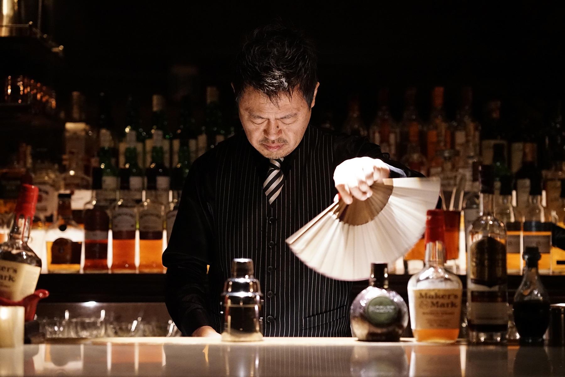 銀座のバー「アポロ」の小松秀徳さん。バーツールとは無縁と思われる扇子で氷をあおぎ、氷の霜を飛ばす独自の手法を編み出した。
