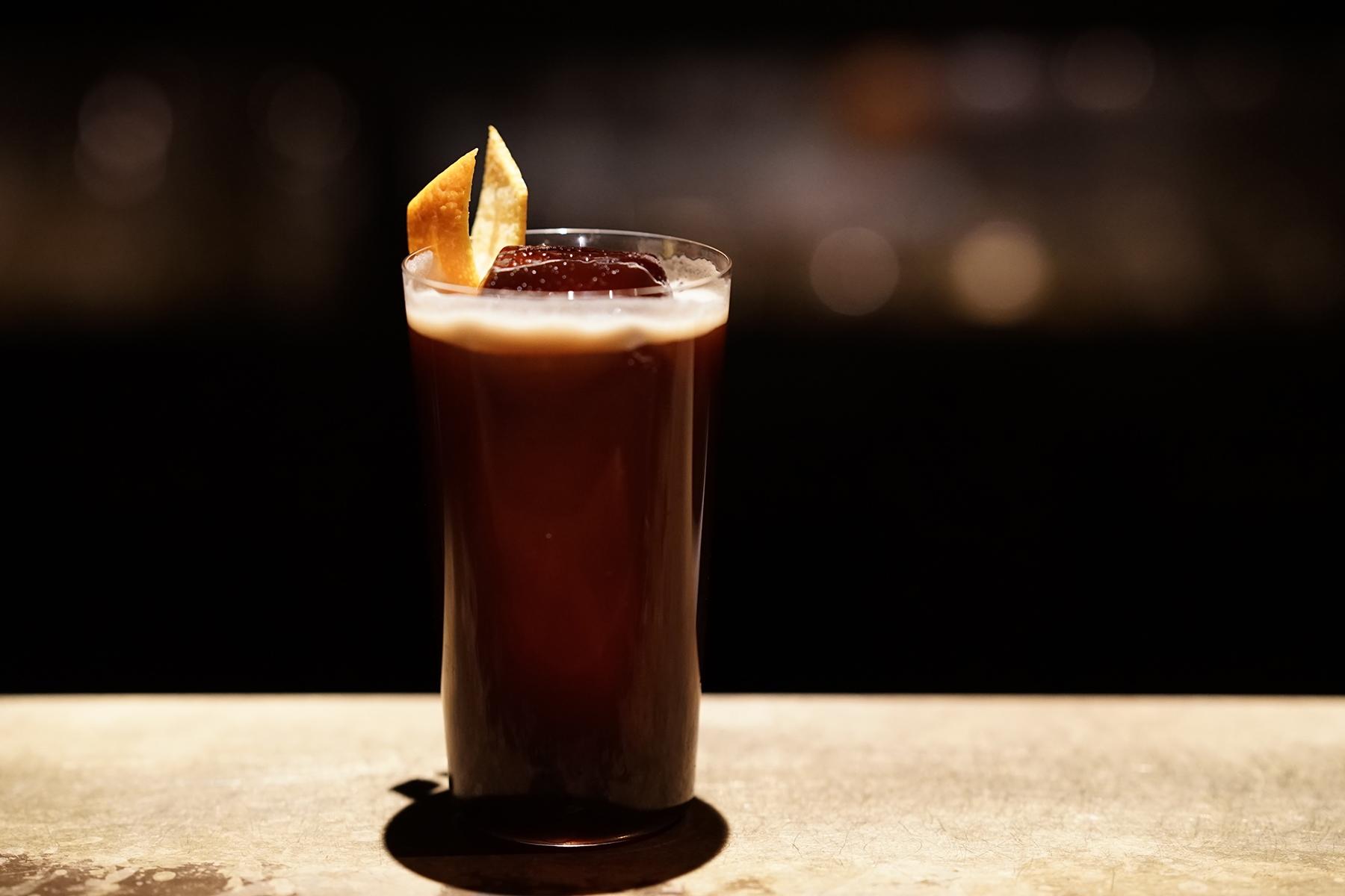 「アポロ」のコーヒーカクテル、カフェアメリカーノ。カンパリ、スイートベルモット、オレンジピールを合わせ、コーヒーと柑橘の風味が相乗。氷がとけてきてもおいしく飲めるよう計算してある。