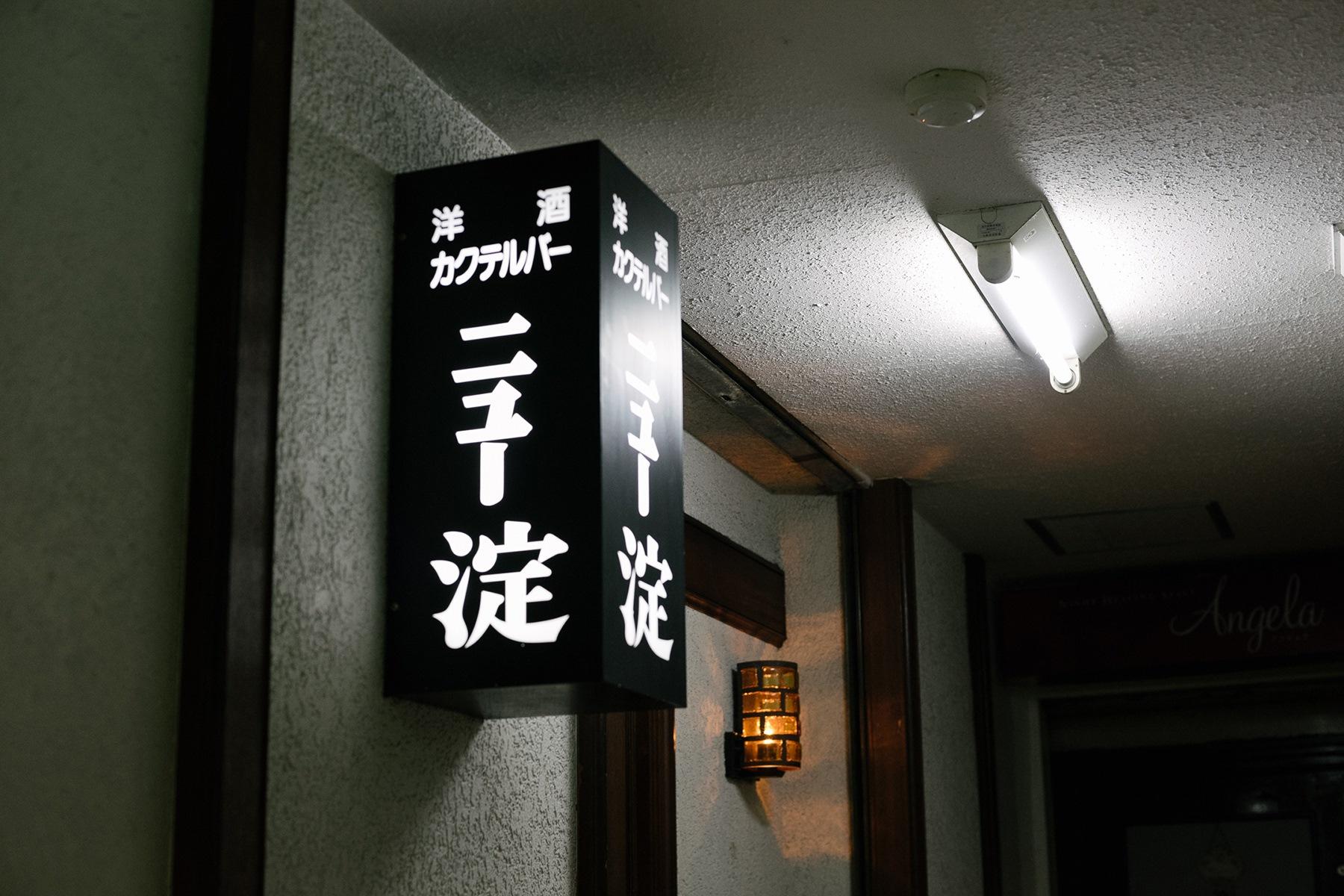 スナックのカラフルな看板に混じり、ひと際「迫」が漂う看板。