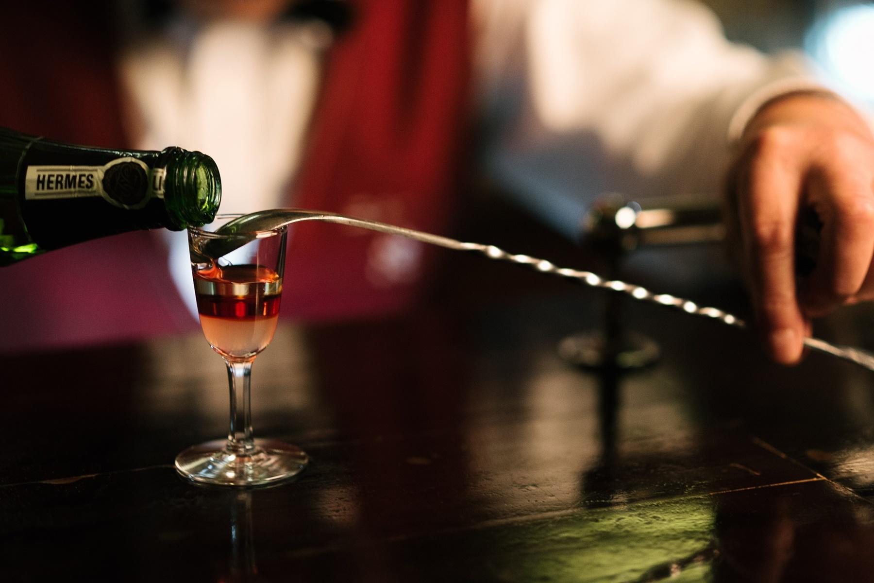 バースプーンの背を伝わらせてそっとお酒を注いでいく。