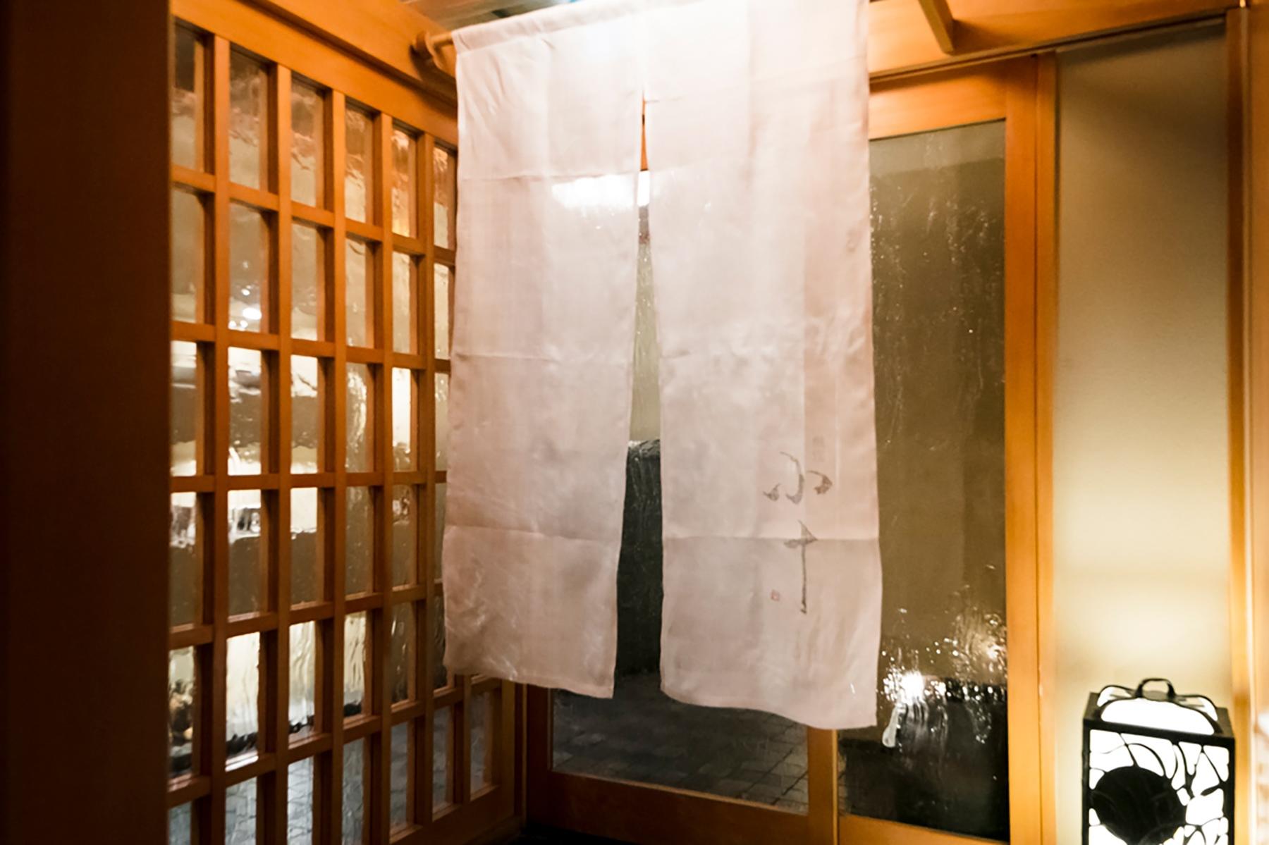 店の入口に掛かる暖簾。ビルの中とは思えぬ佇まい。