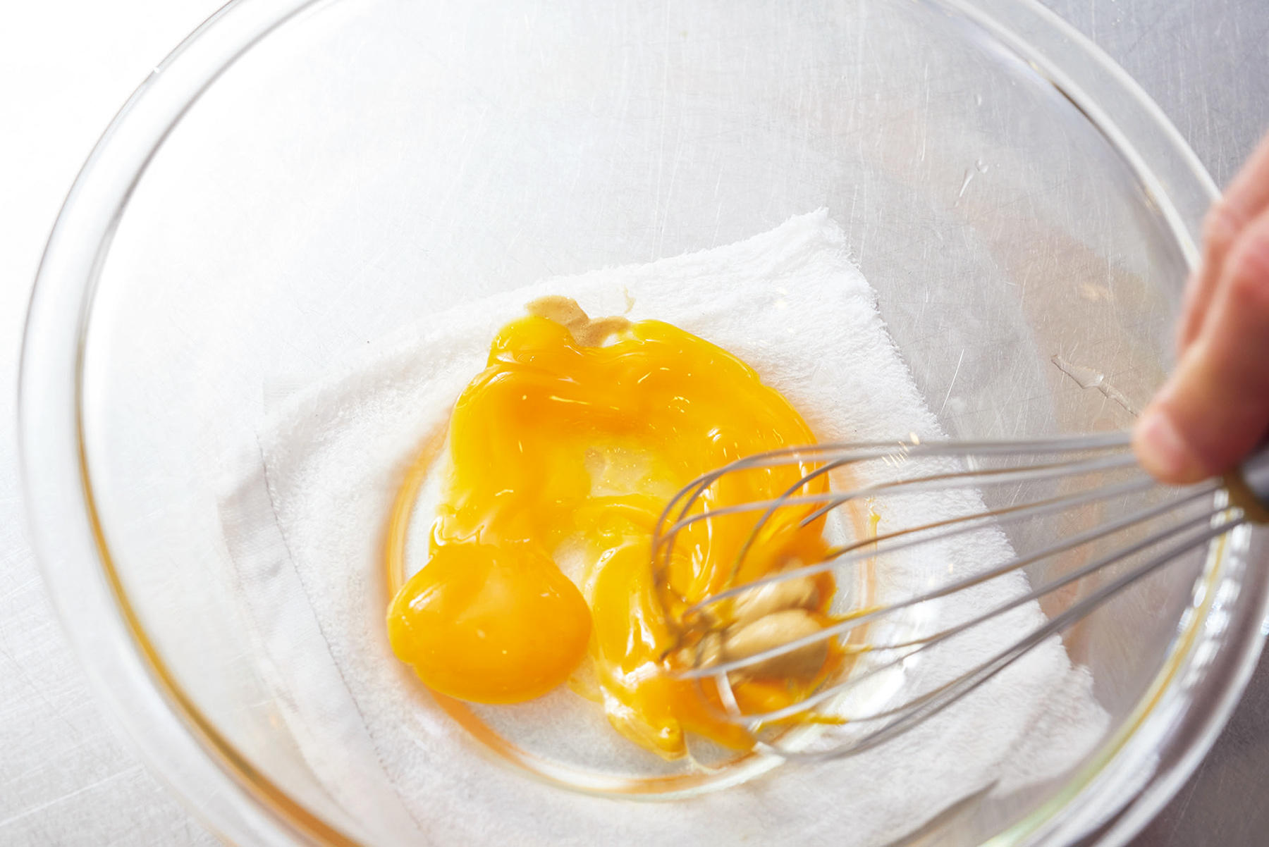 卵黄、マスタードに油を加えて混ぜる