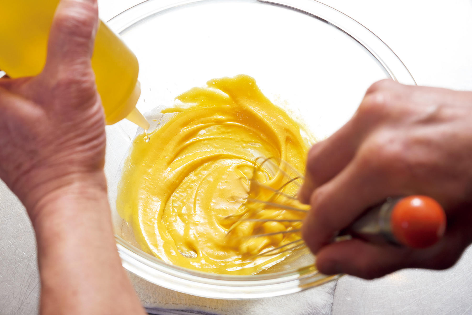 卵黄、マスタードに油を加えて混ぜる