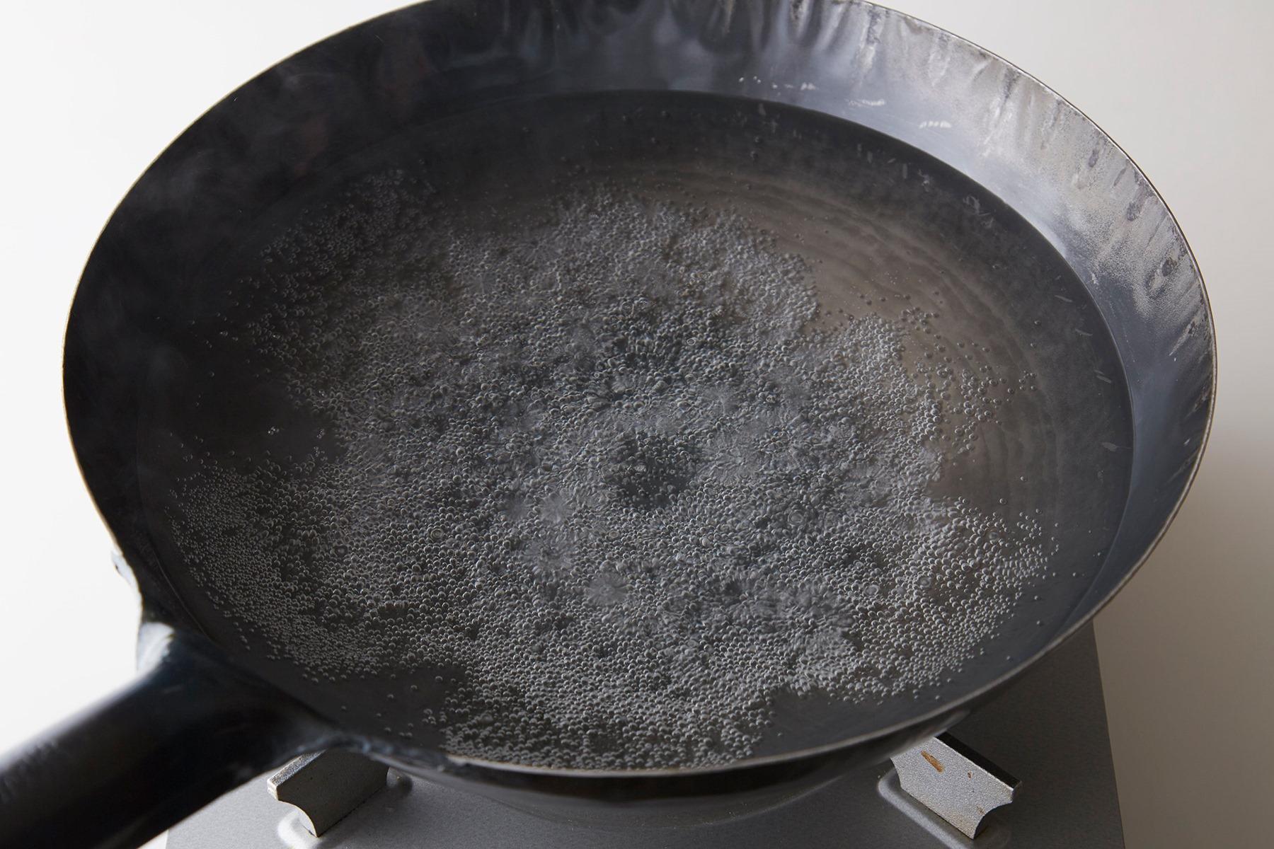 多くの中華鍋は、鉄製。さびないように表面に加工がされているものが多いので、使い始めはまず中華鍋に水をたっぷりわかして、しばらく強火にして沸騰させます。水を入れ替えてそれを2回くりかえしてください。