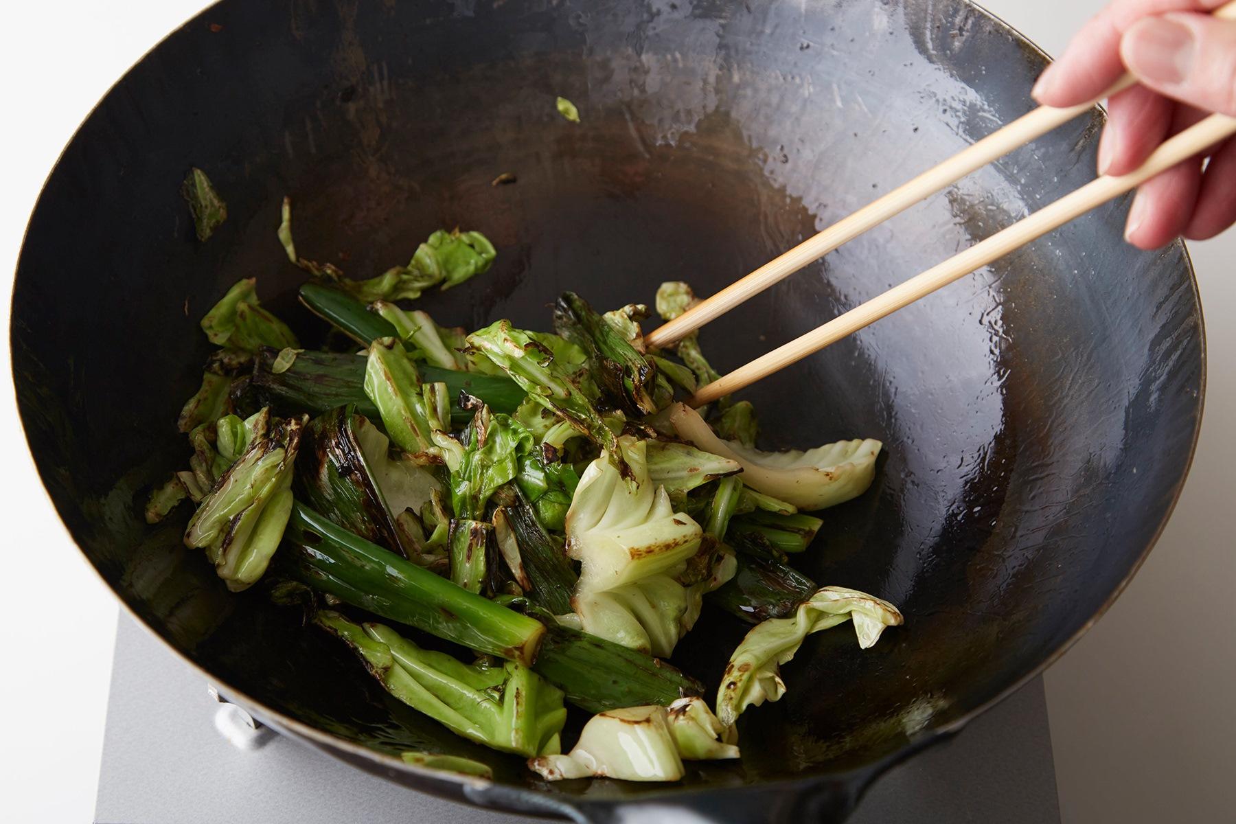 次に、鍋に油をしみこませます。油を大さじ3程度入れて中火にかけ、キャベツの外葉や長ねぎの青い部分などのくず野菜を炒めます。混ぜながら全体に油をなじませて。野菜が少し焦げるくらいまで炒めれば、準備OKです。