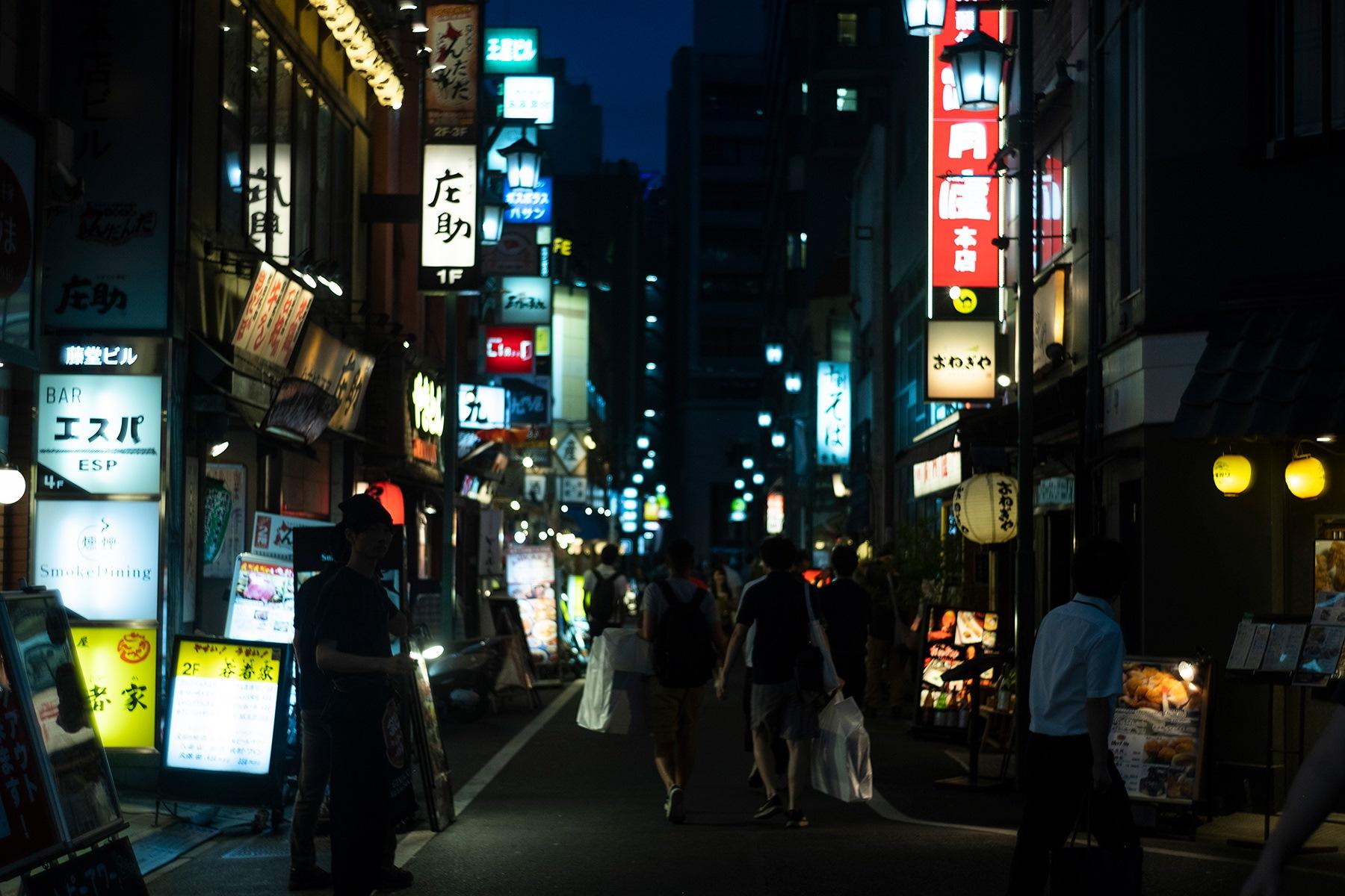 梯子をする酔客で賑わう「新宿末廣亭」前。
