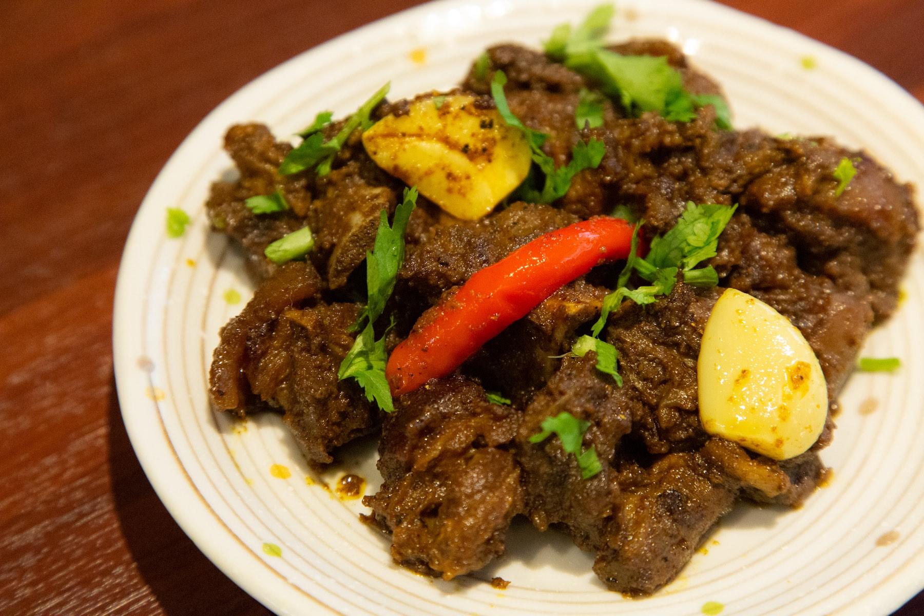 “フライドやぎ肉”700円。脂が乗ってねっとりとした山羊肉は強めのスパイスで味付けされる。中毒性高めの一皿。