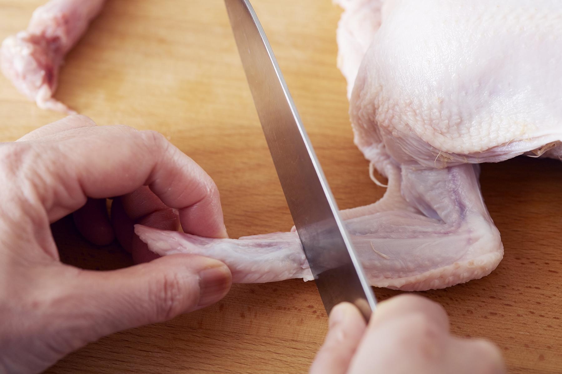 手羽先も関節にある骨のくぼみに包丁の根元をあて、切る。