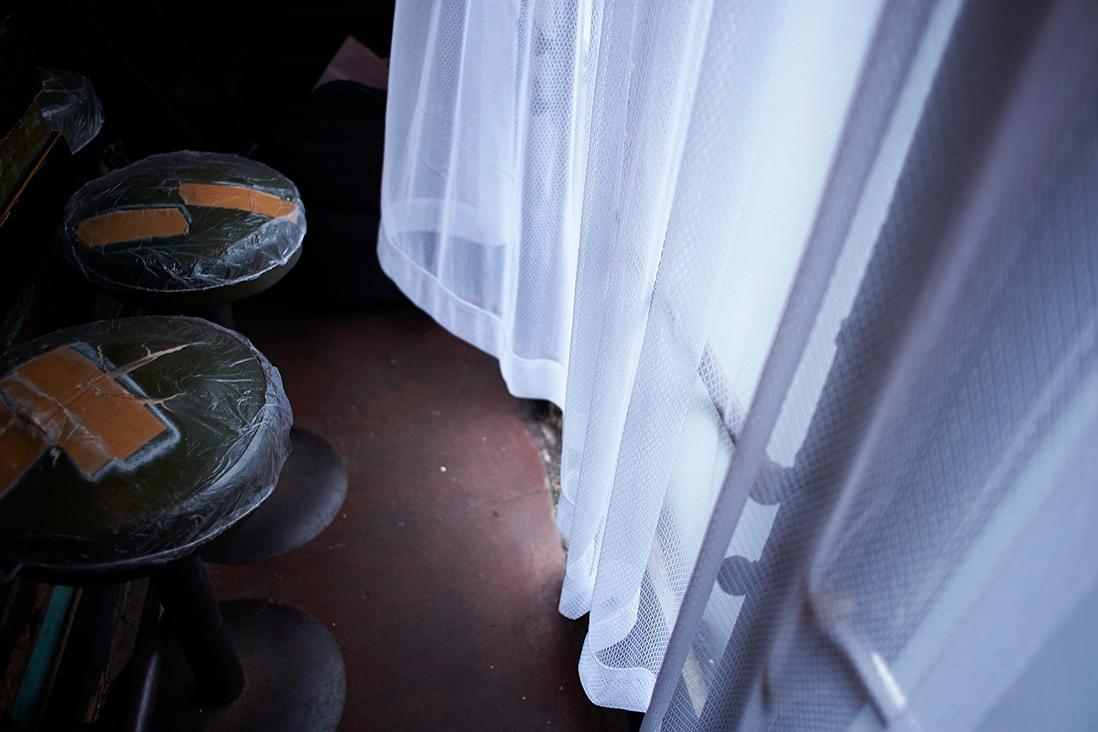 風に揺れるレースのカーテン。何度も修理した年季の入った椅子。