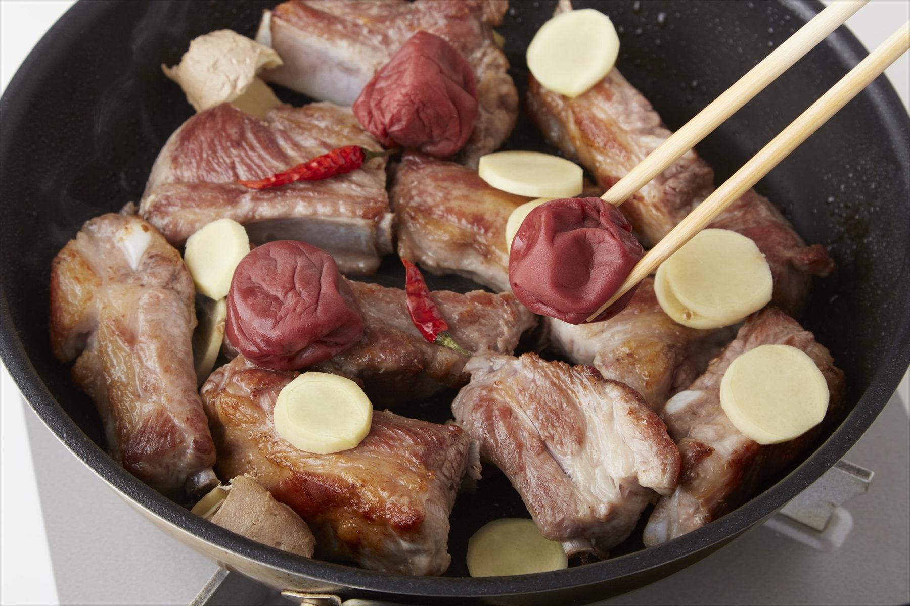 均等に味がいきわたるように、梅干し、生姜などはスペアリブの全体に散らす。蓋をして弱火で40~50分煮る。