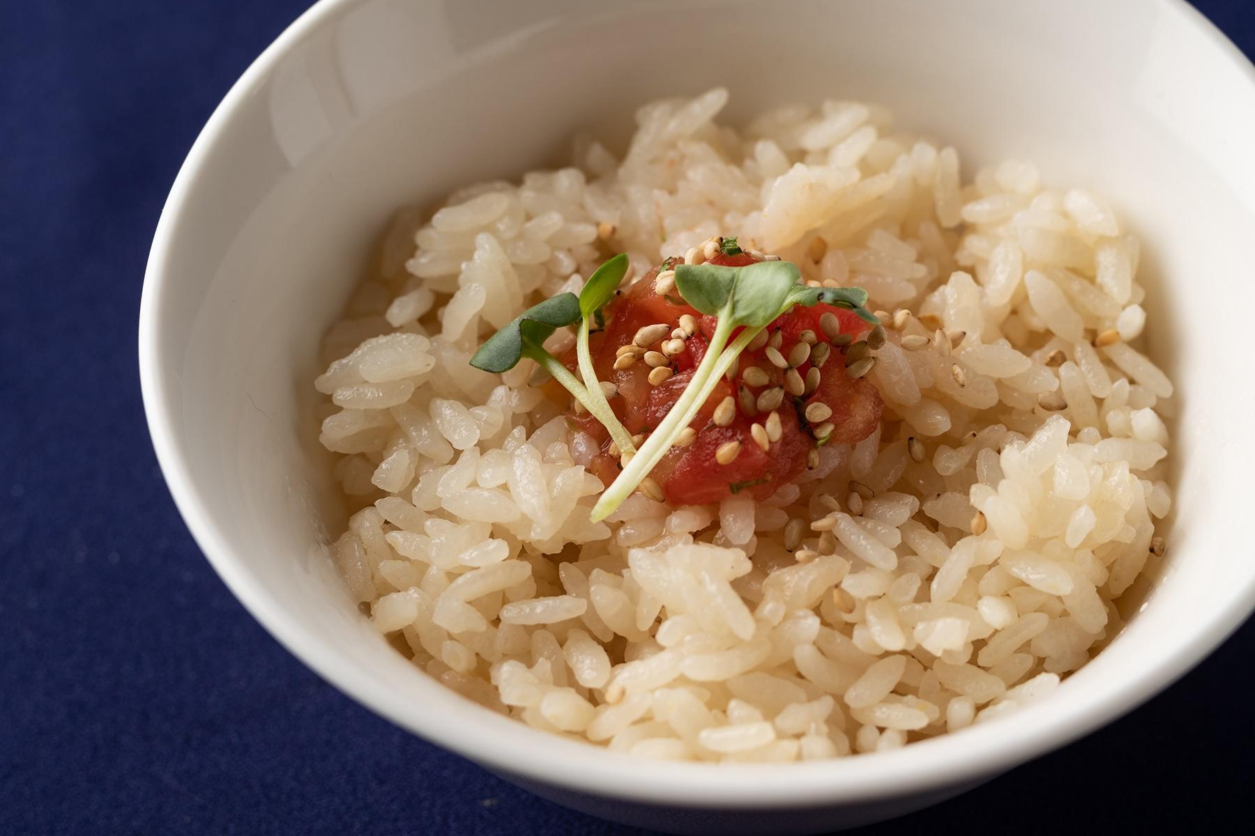 鯛出汁で炊いた “鯛ダシご飯”100円。 トッピングされた刻んだトマトとセロリが爽やか。最後にスープに入れて食べてもおいしい。