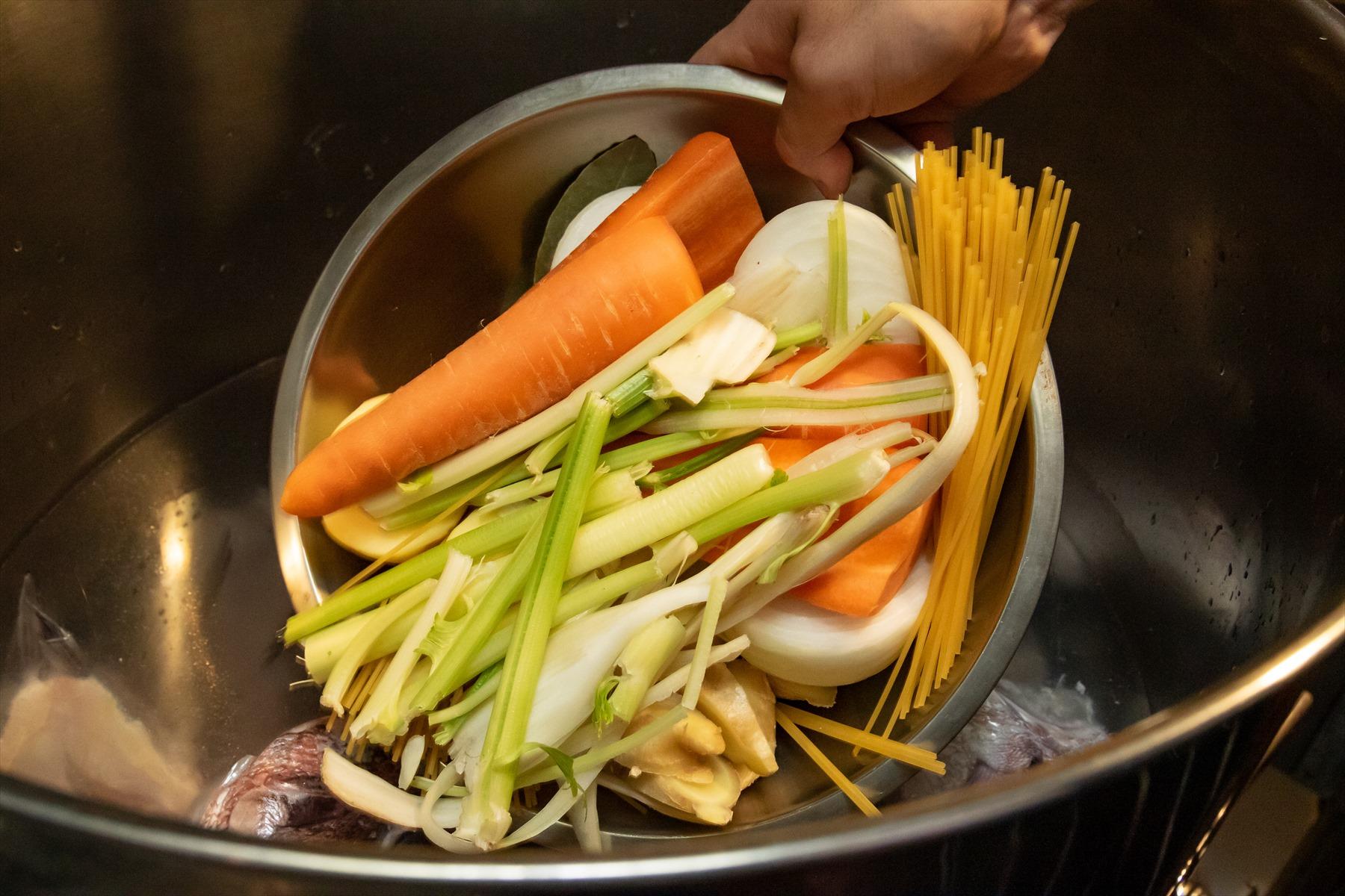 下処理をした真鯛のアラを入れ、水を張った寸胴鍋。野菜類も入れて、一緒に炊き上げる。