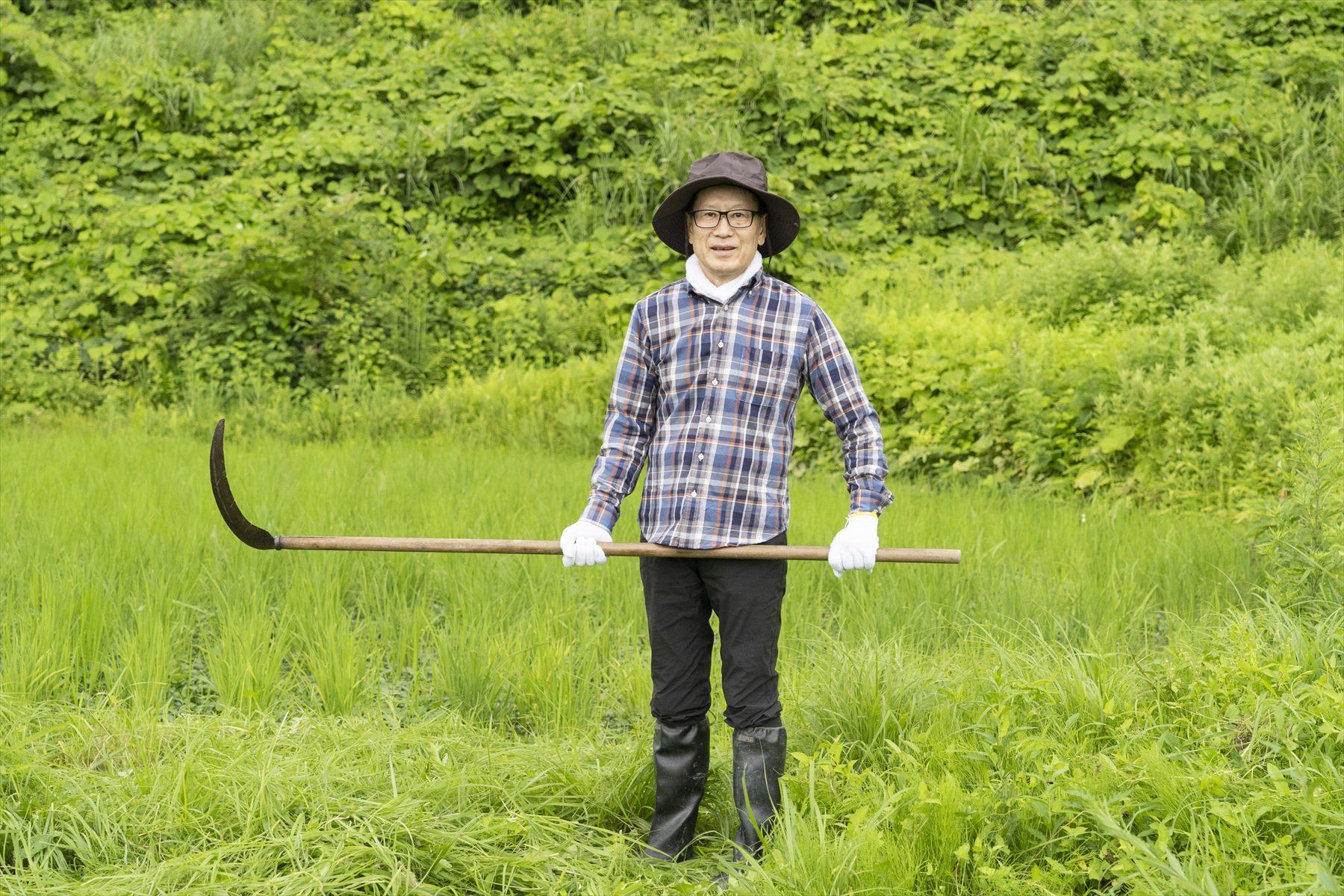 どこかハロウィンを思わせる佇まいの藤原智美さん。大きな鎌を手にして、ご満悦。