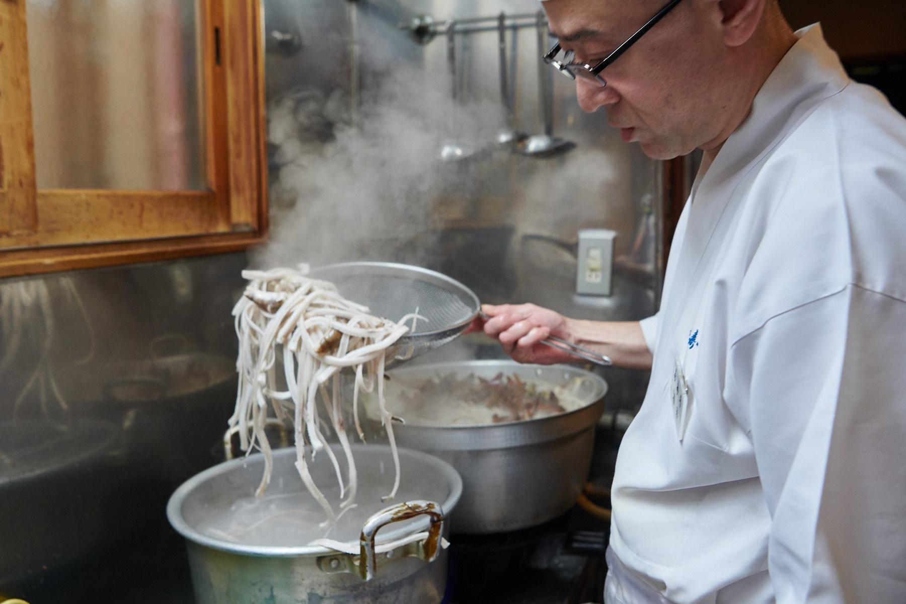 解凍した穴子の頭と中骨を沸騰した湯でゆでこぼす
