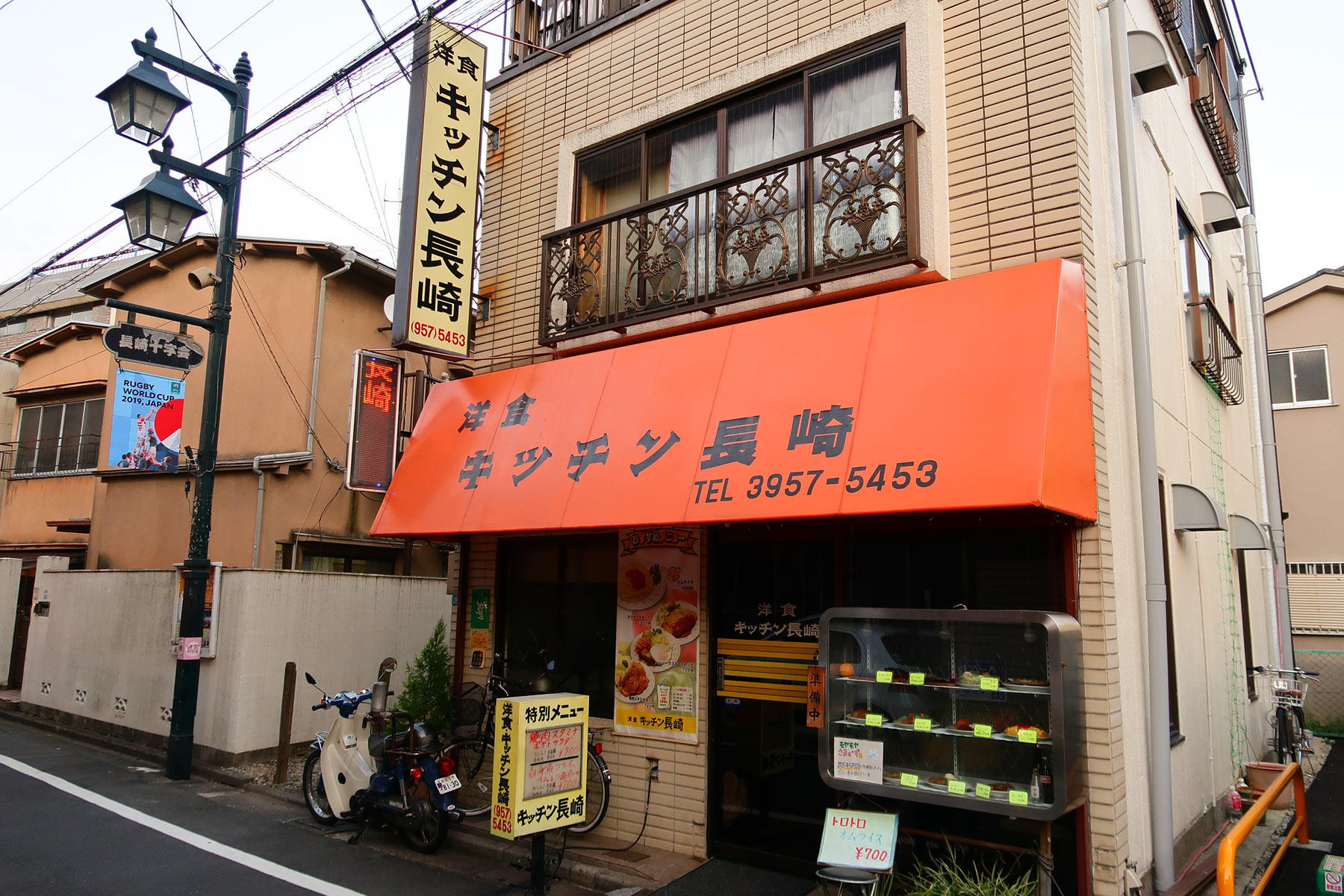 オレンジ色の庇テント