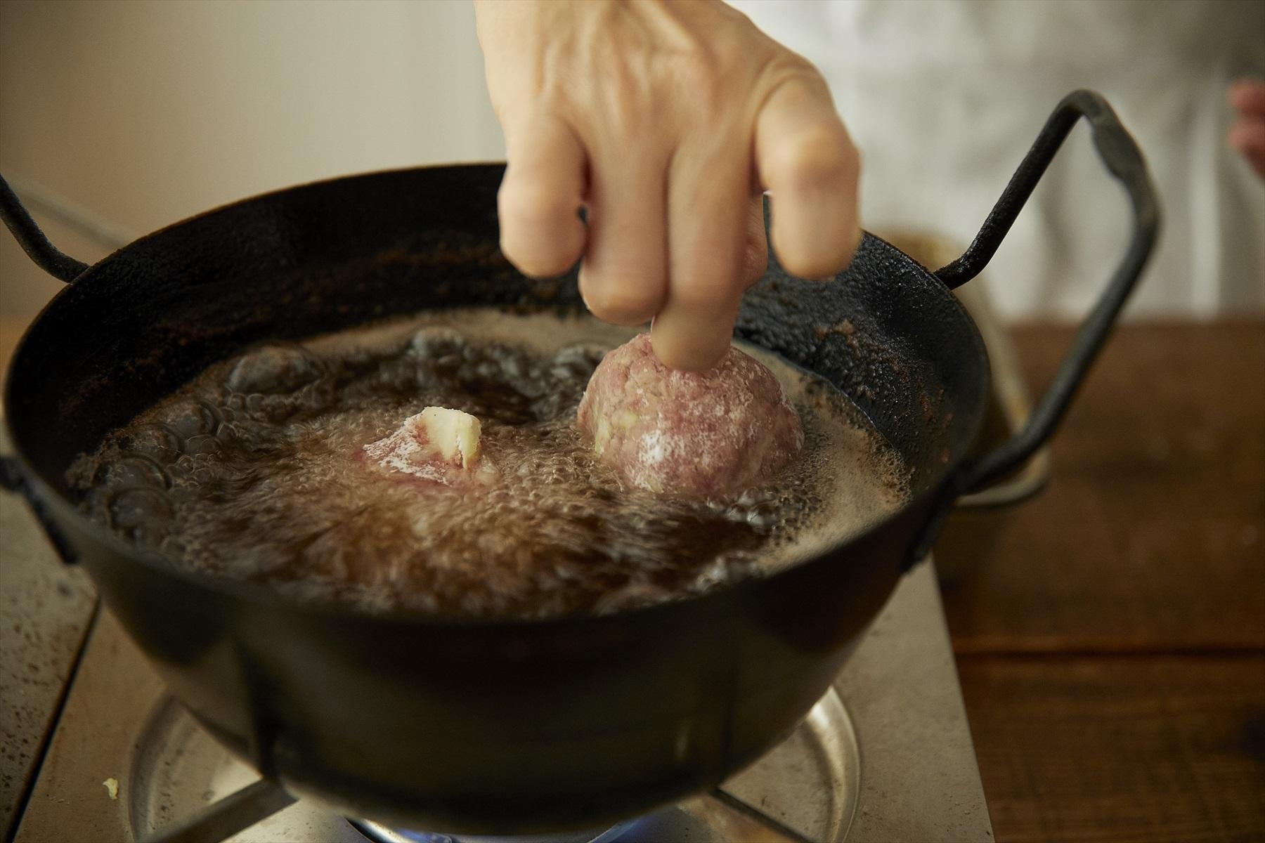 軸をつまんで持ちながら揚げ油の中にいれる