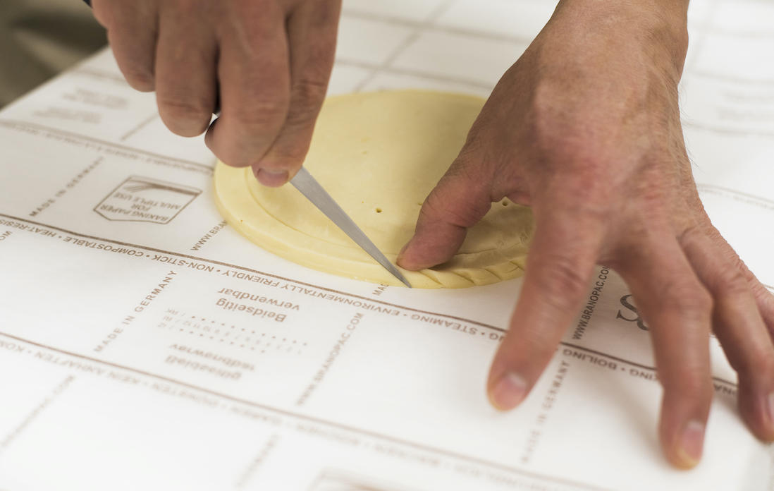 縁を指で押さえながらナイフの背で切り込みを入れる