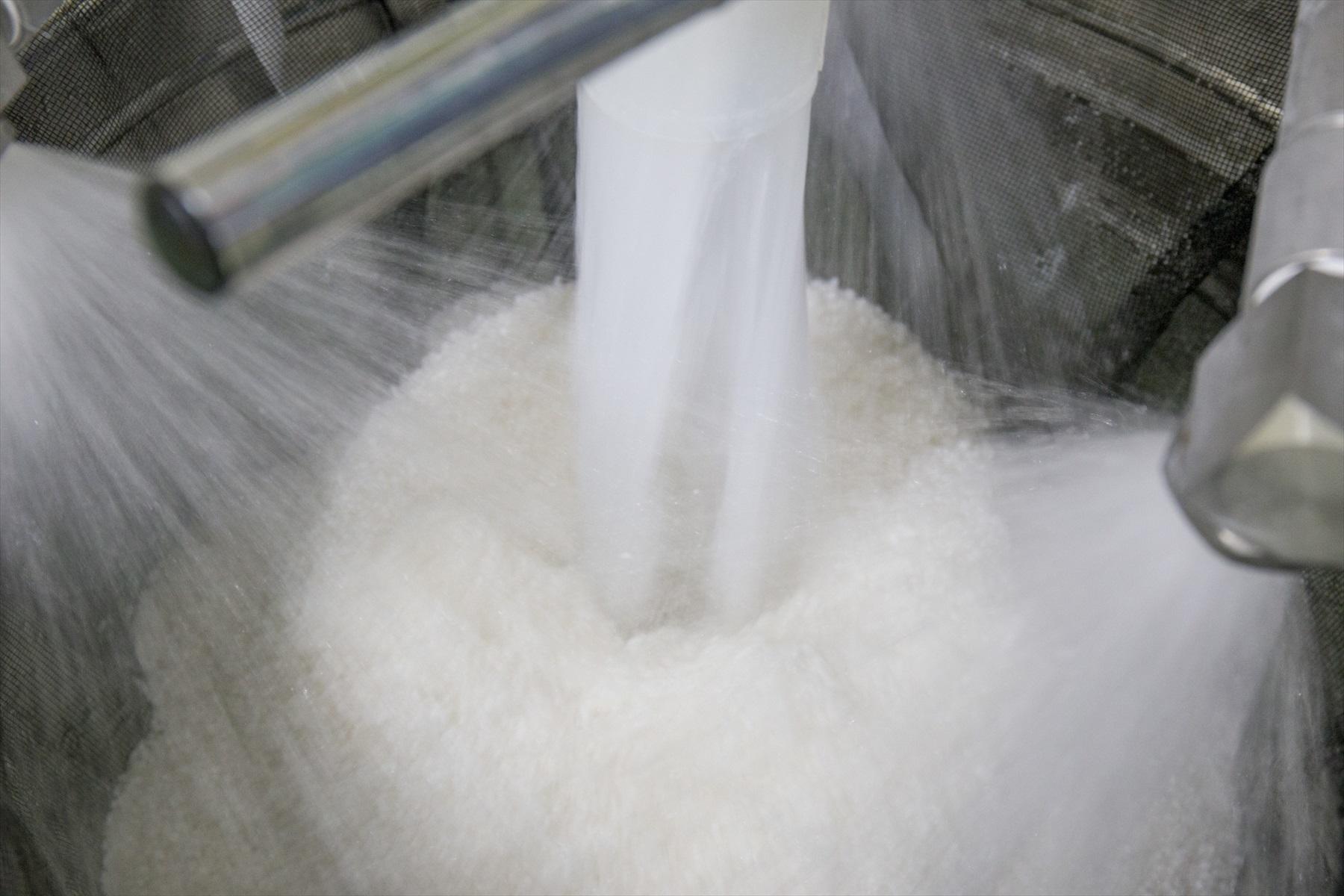 洗米機から米が下に流れ落ちてくる様子