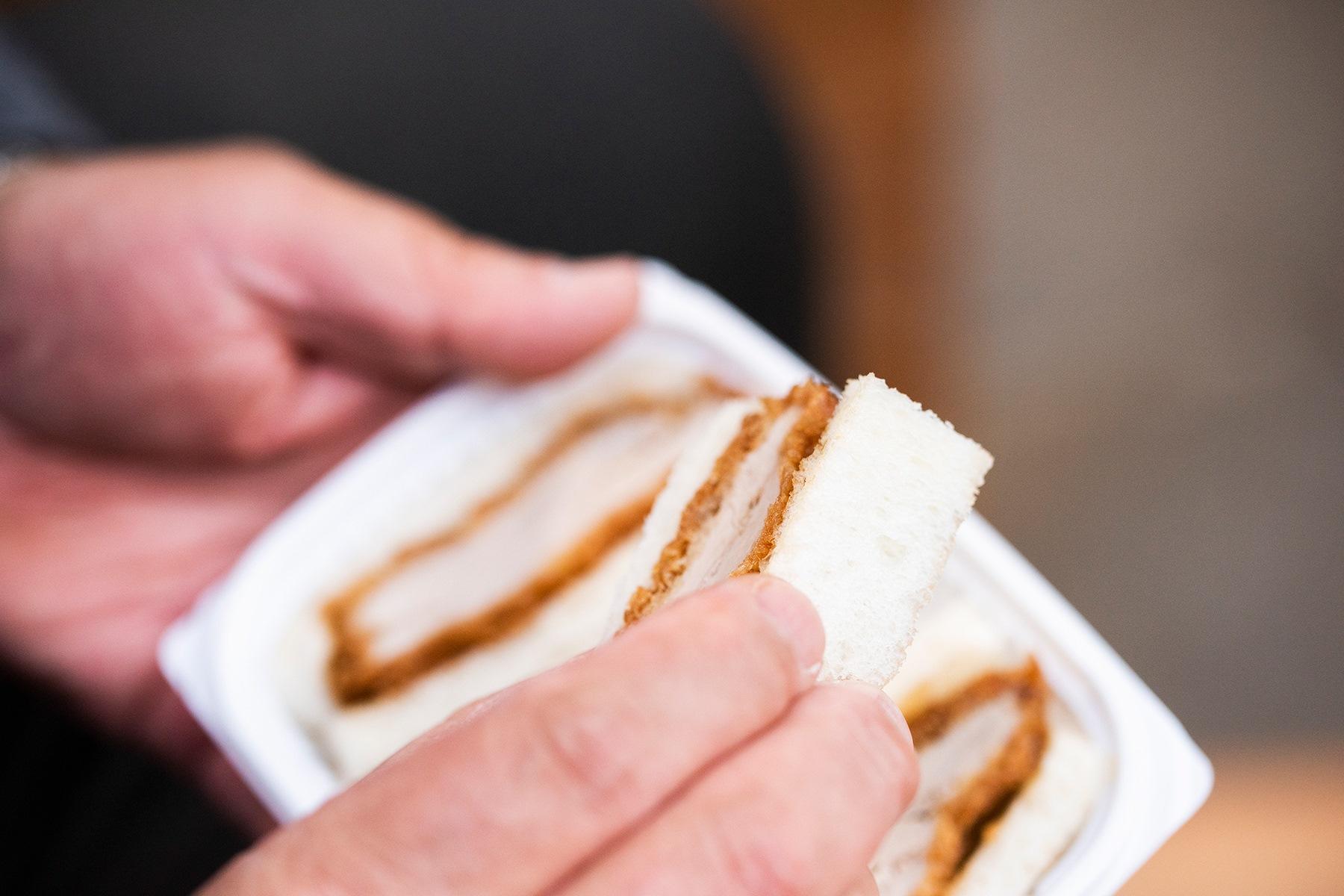 ひれカツサンドを食べる手