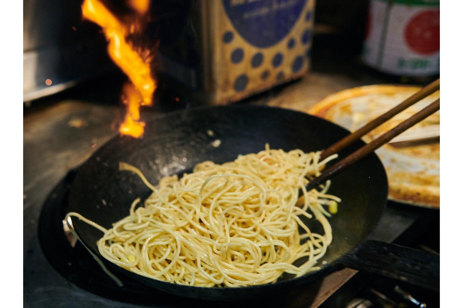 スパゲティを炒める様子