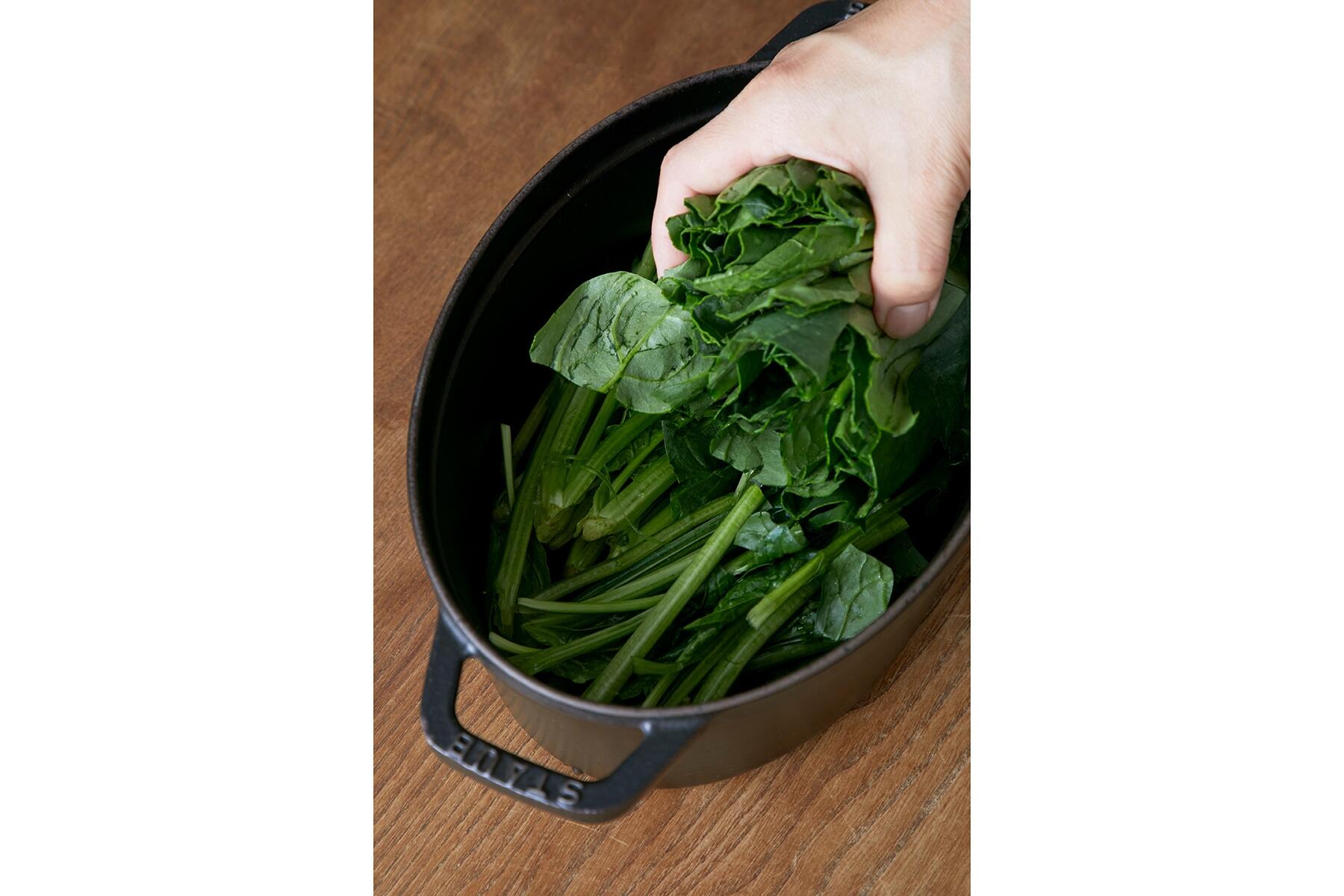 鍋にほうれん草を入れる