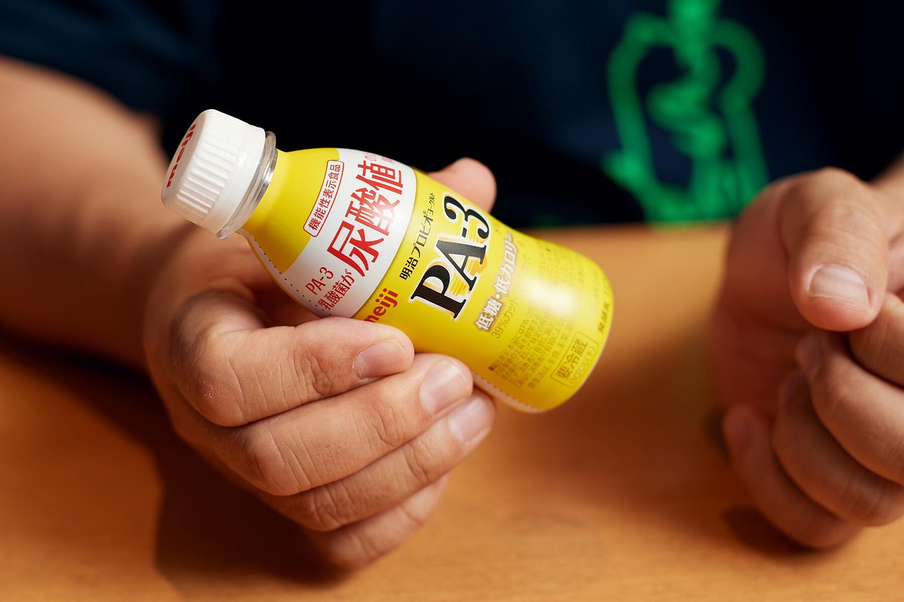 ヨーグルトの容器を持つ手