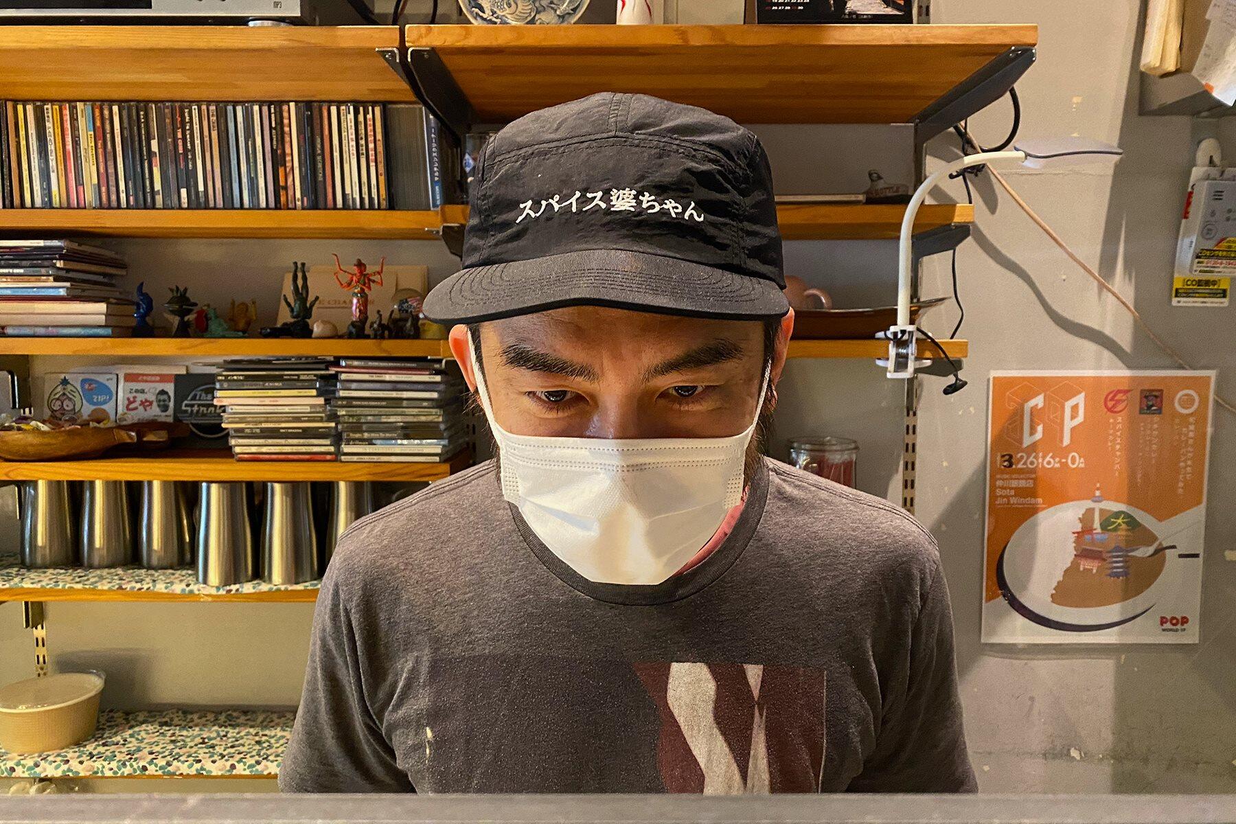 帽子を見せる店主