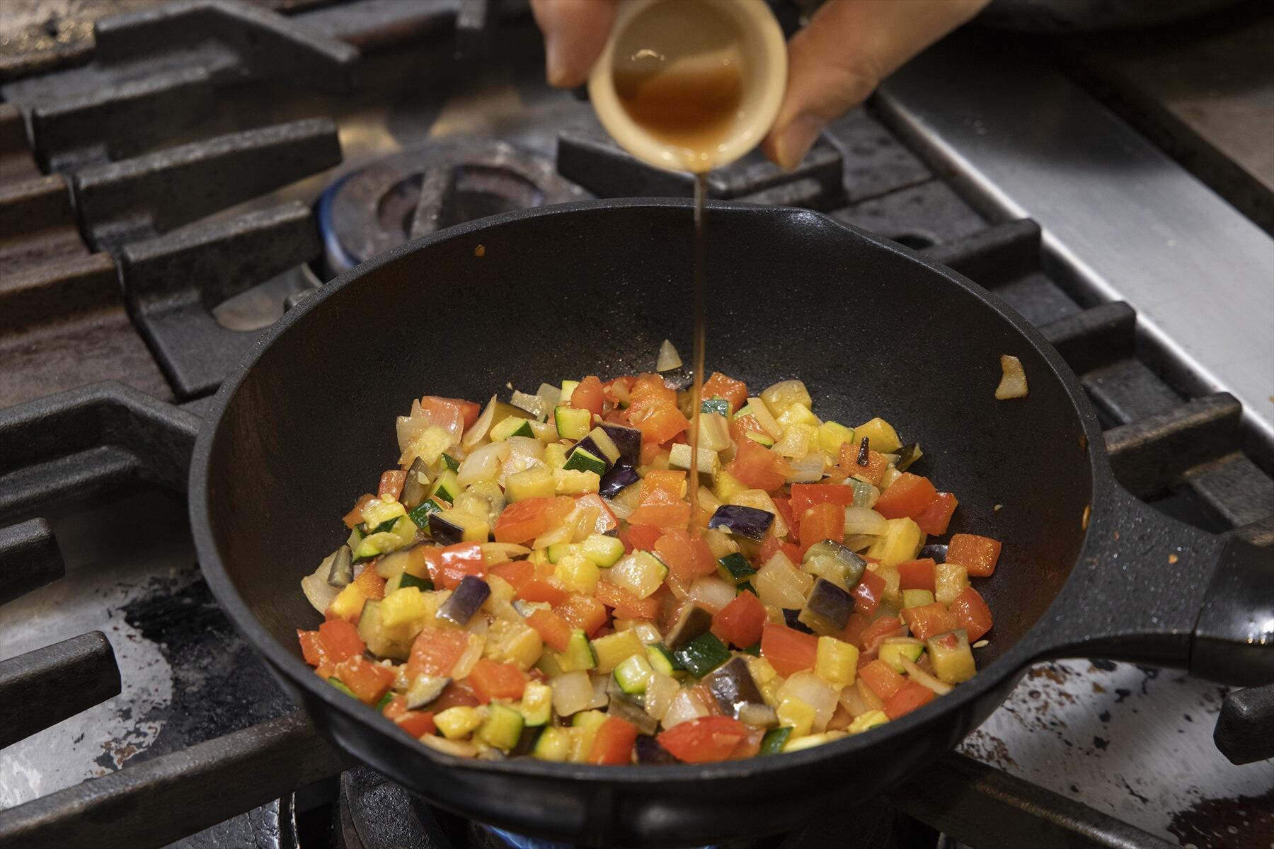 赤ワインビネガー、粒マスタードでソースを仕上げる