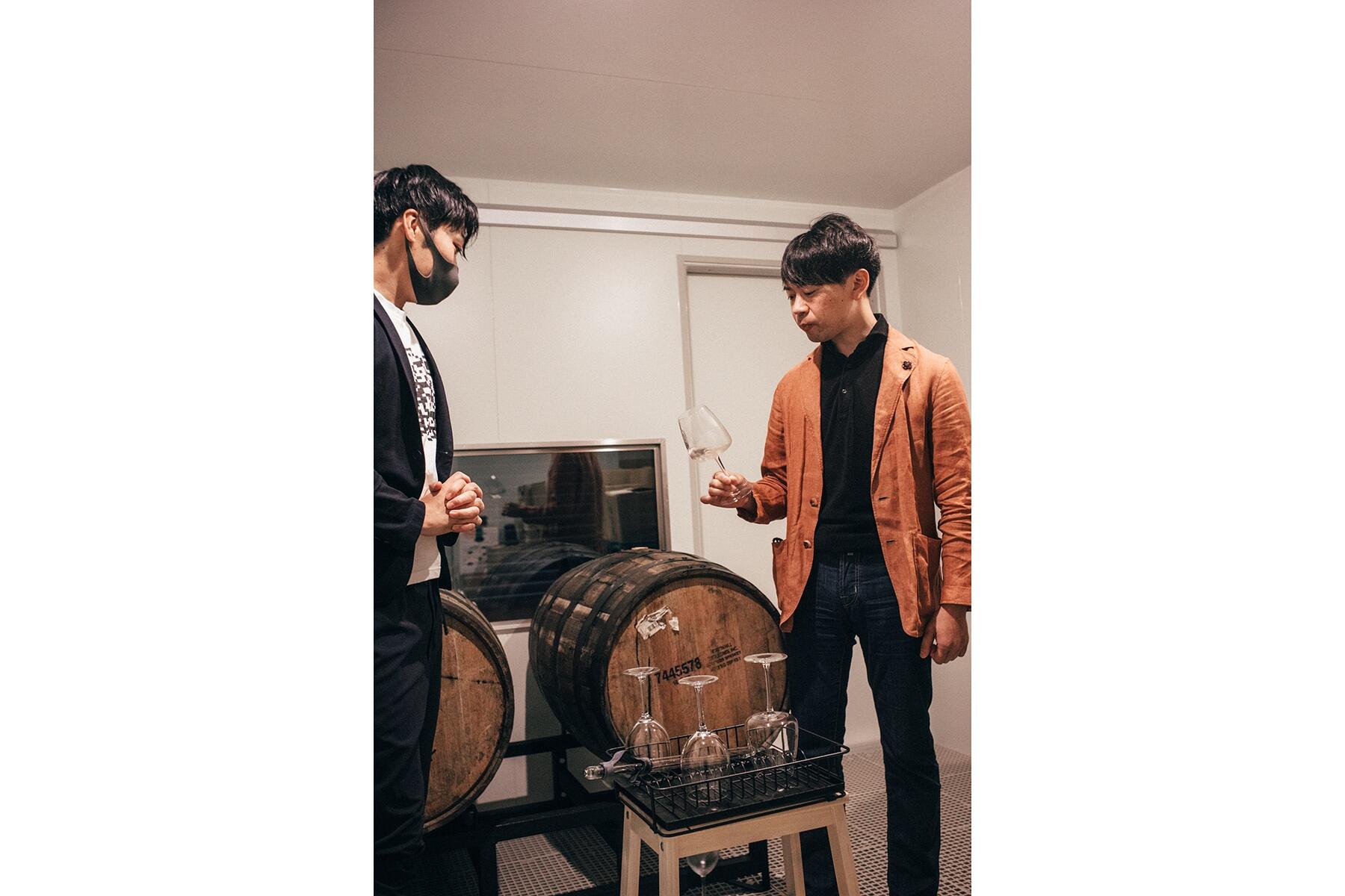 樽を挟んで立つ男性2人