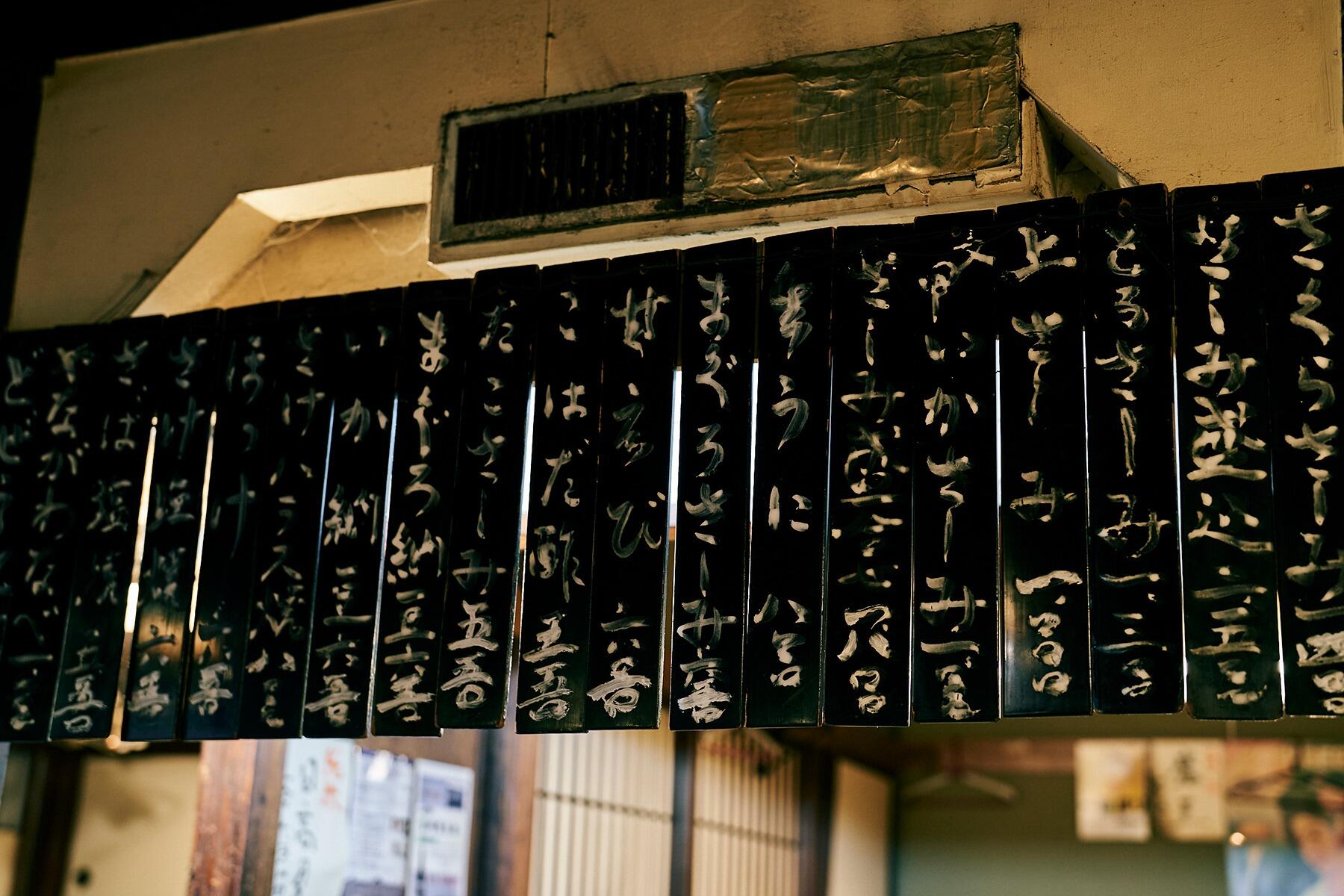 壁にかかった木製の品書き札