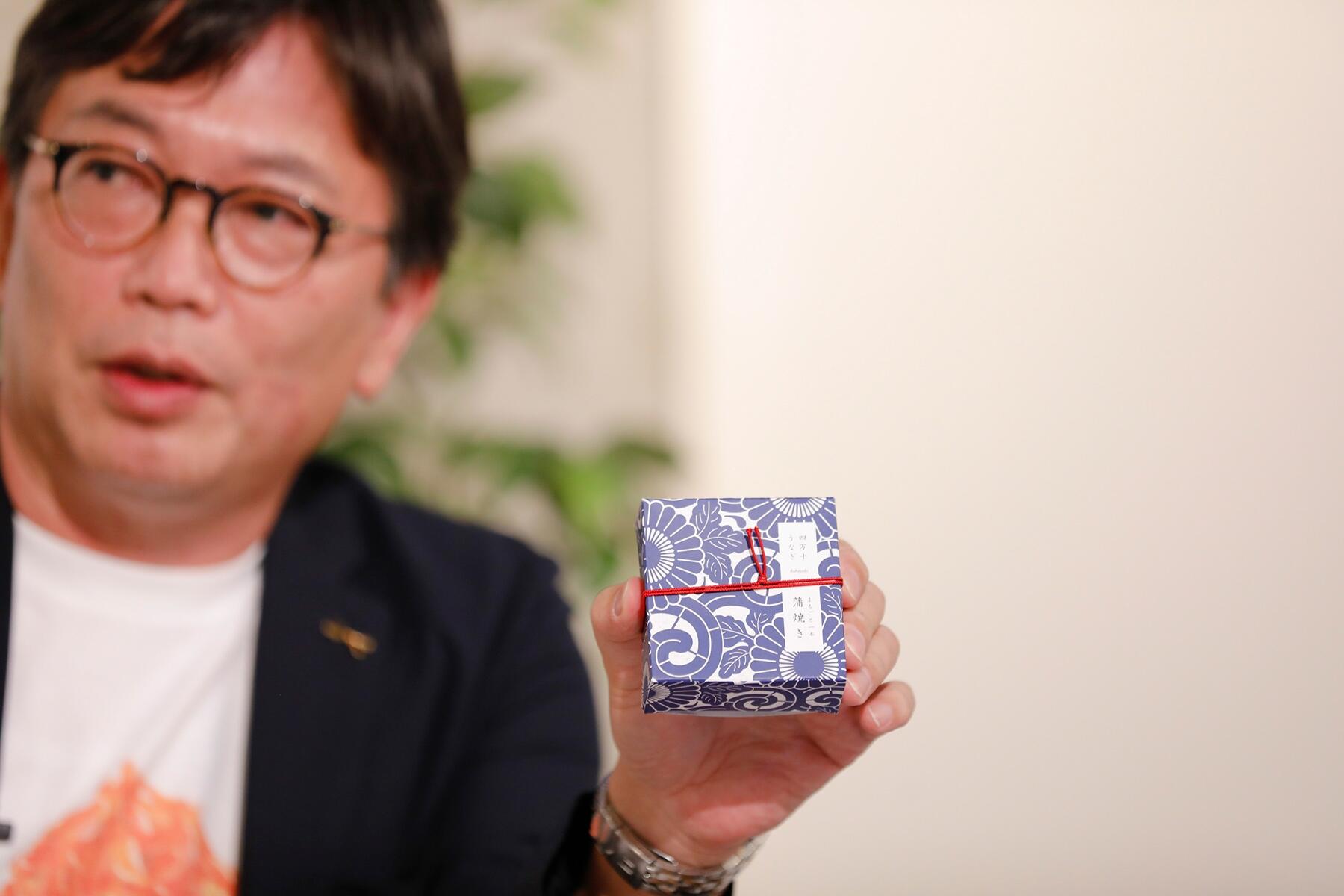 四万十鰻の缶詰を持つ植野編集長