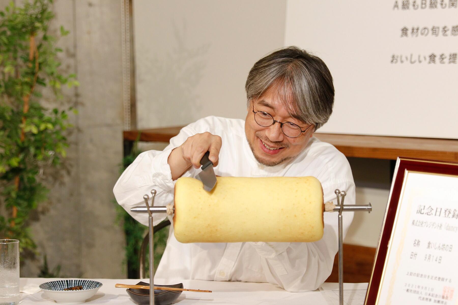 バウムクーヘンを切る小山薫堂さん