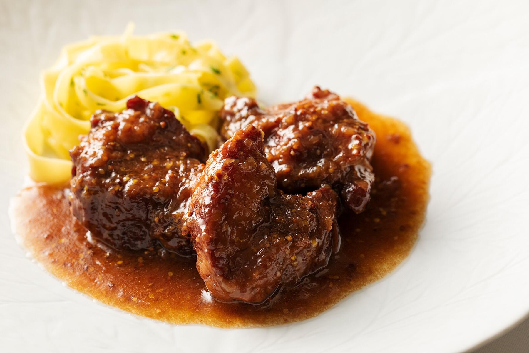 「赤ワインとオレンジジュースで煮込んだ豚肩ロース 粒マスタードのアクセント」