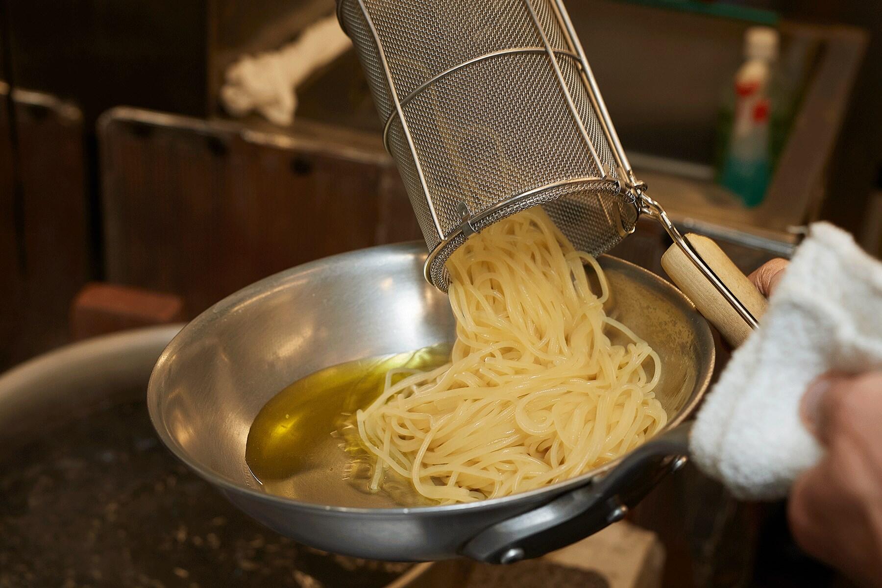 パスタをフライパンに入れる