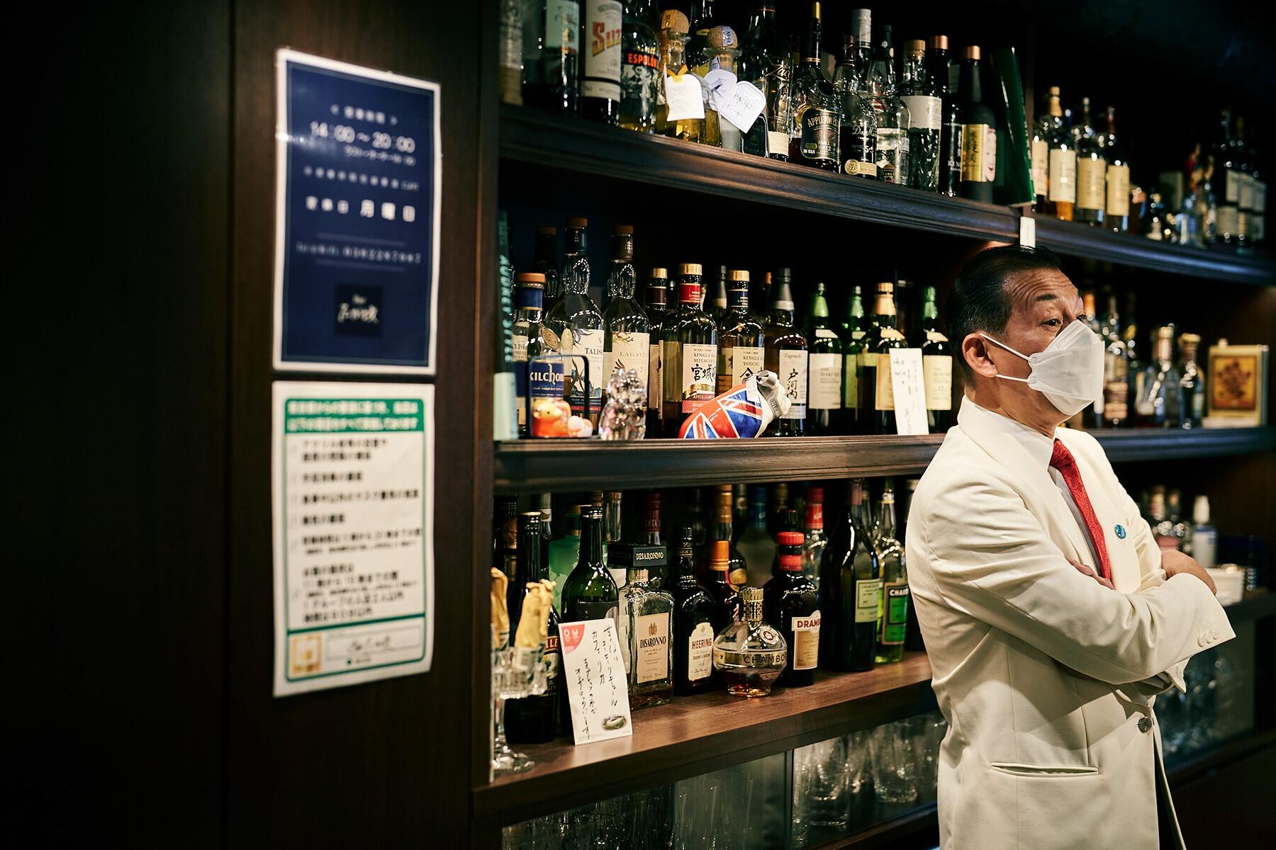 酒棚をバックにオーナーバーテンダーの高坂壮一さん