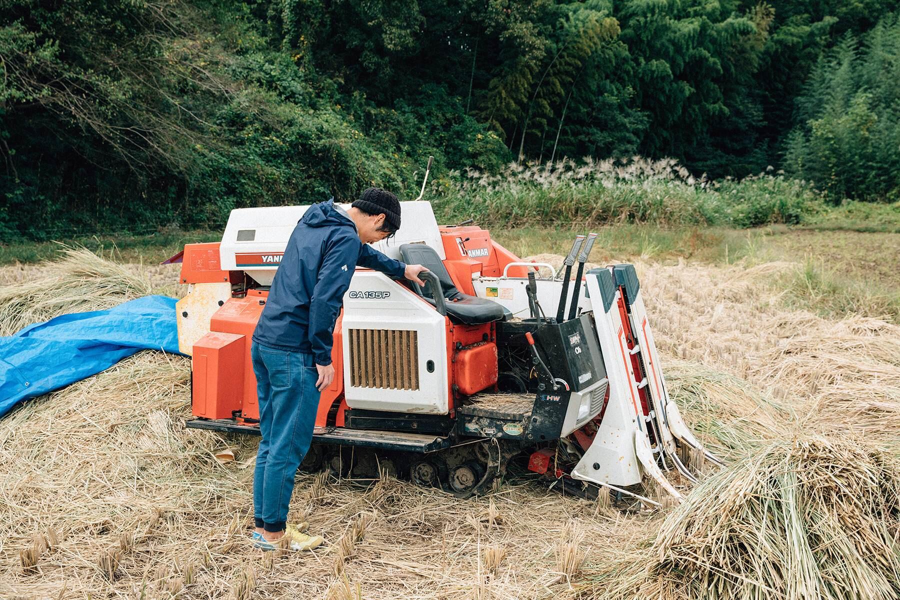 機械に手をついてうなだれる男性