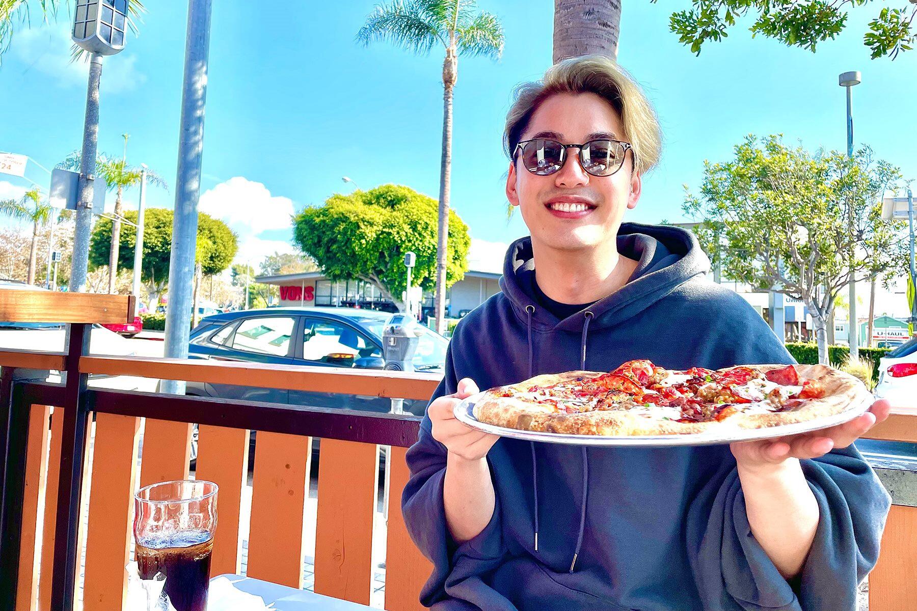 ピザを持つ大野さん